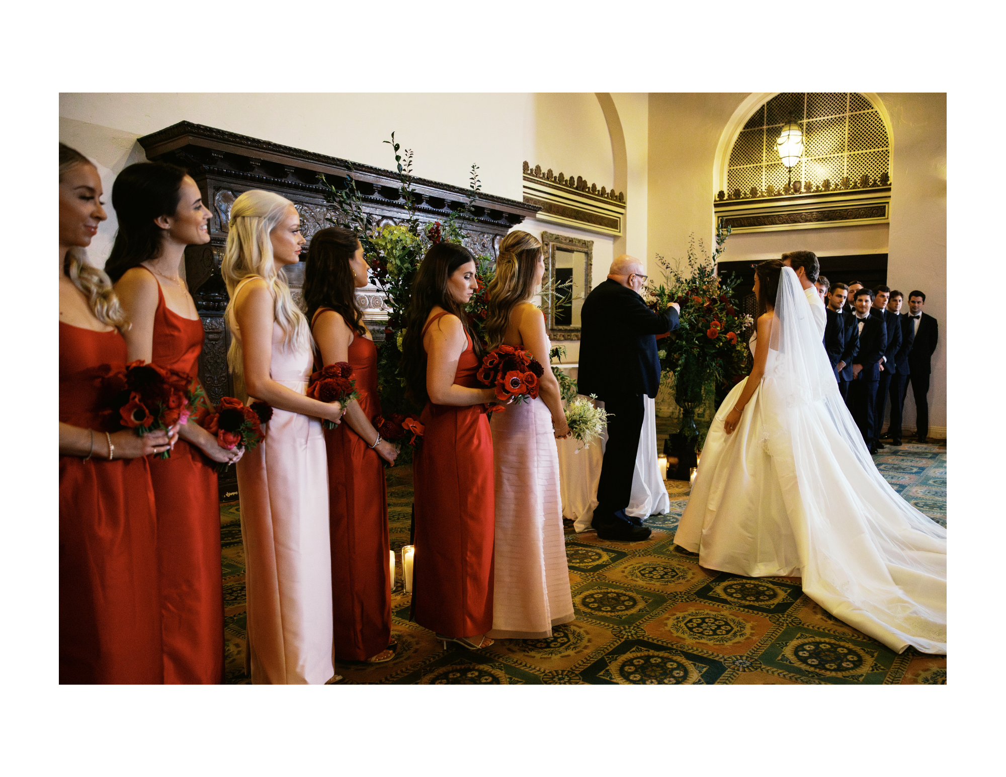 The bride stands with groom and bridal party during the wedding ceremony. The bride is wearing a strapless ballgown. Groom is wearing a white. Photograph taken by wedding photographer Sheridan Mangold at Congressional Country Club in Bethesda, MD.