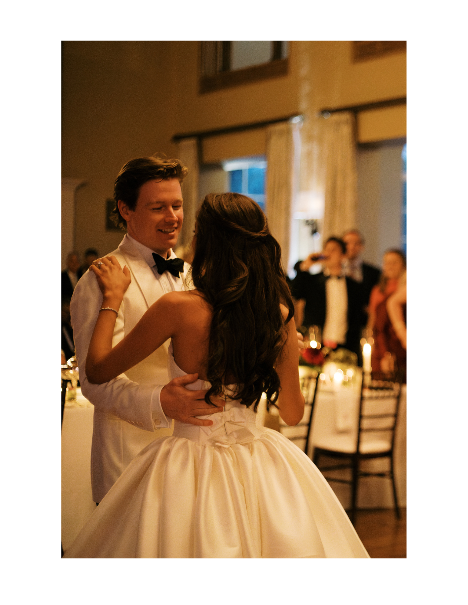 The bride and groom dance together during the reception in the main ballroom. Photograph taken by wedding photographer Sheridan Mangold at Congressional Country Club in Bethesda, MD.