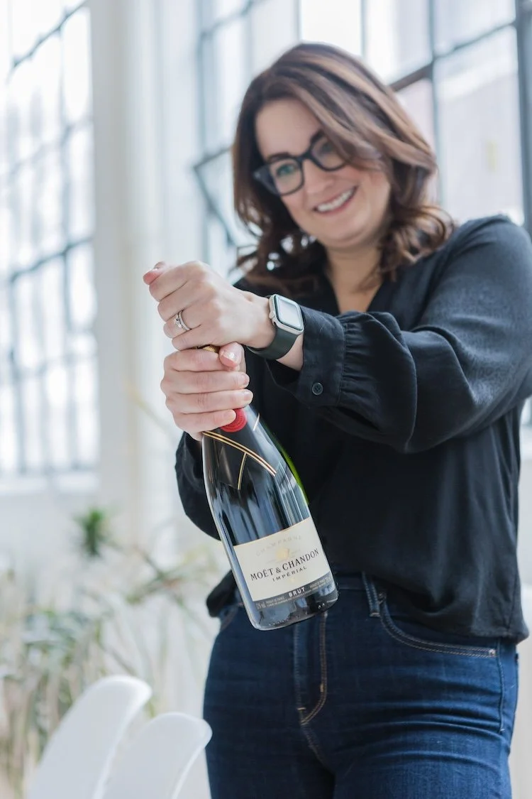Woman popping a bottle of champagne