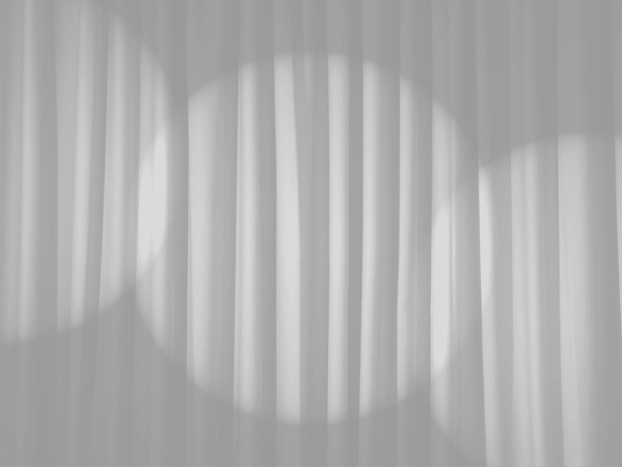 Black and white image of stage curtain with three spotlights on it.