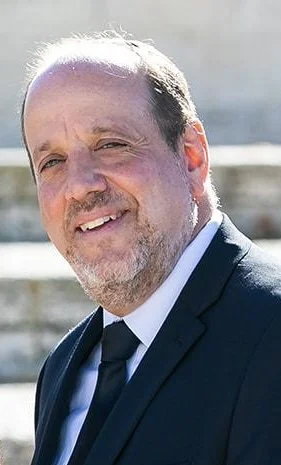 Man in suit smiling outdoors