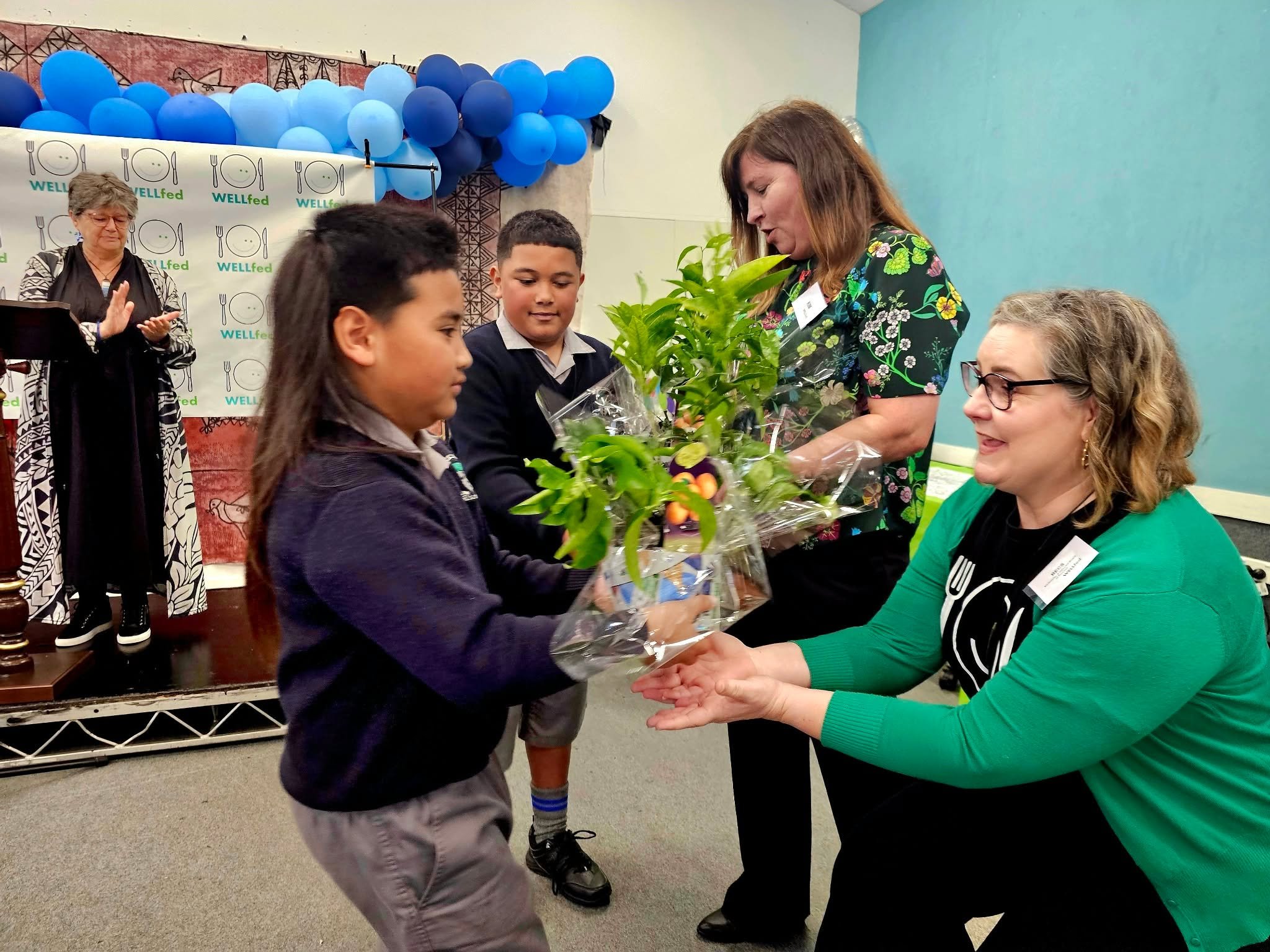 Co-founders Bex and Kim receive a koha from Holy Family School students