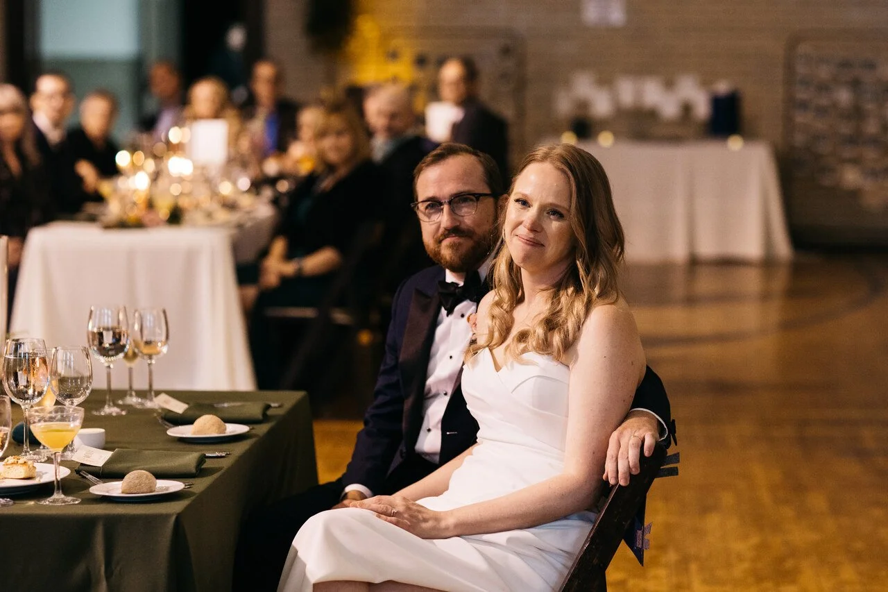 086-couple-sweetheart-table-listening-toasts-bok-gymnasium.jpg
