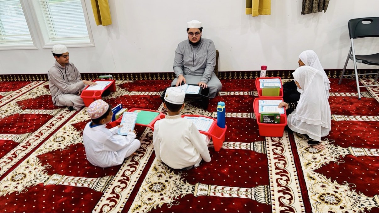 AlMaktab students reading with their teacher at Baitul Mukarram Masjid in Danbury, CT