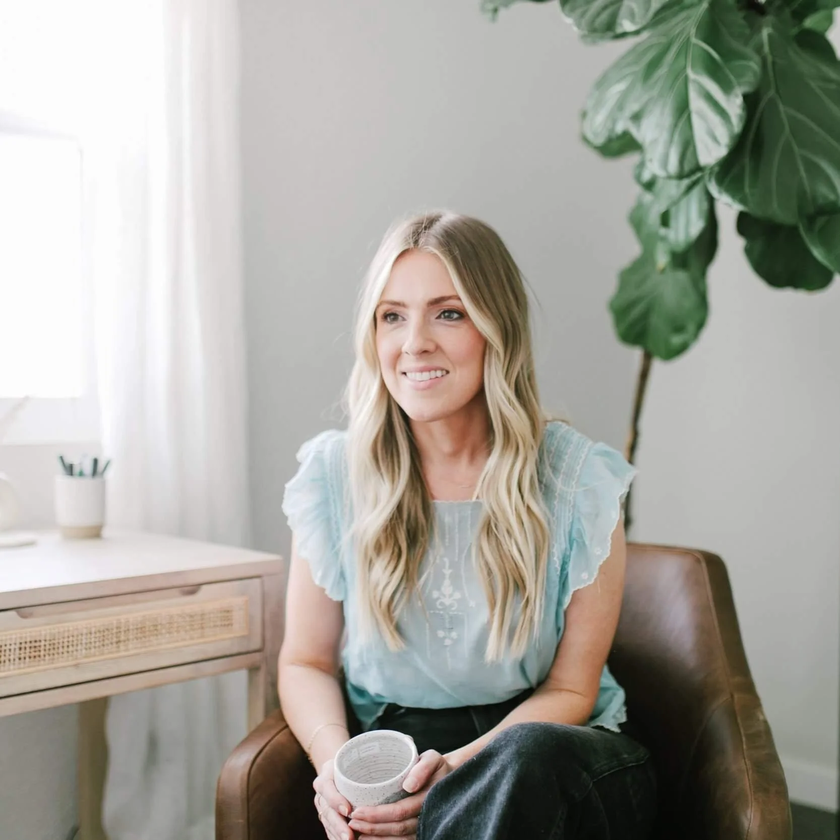 Somatic therapist, Janelle Nelson, seated in a calm, light-filled office, offering somatic therapy for parents in Carlsbad, CA to support safety and nervous system regulation.
