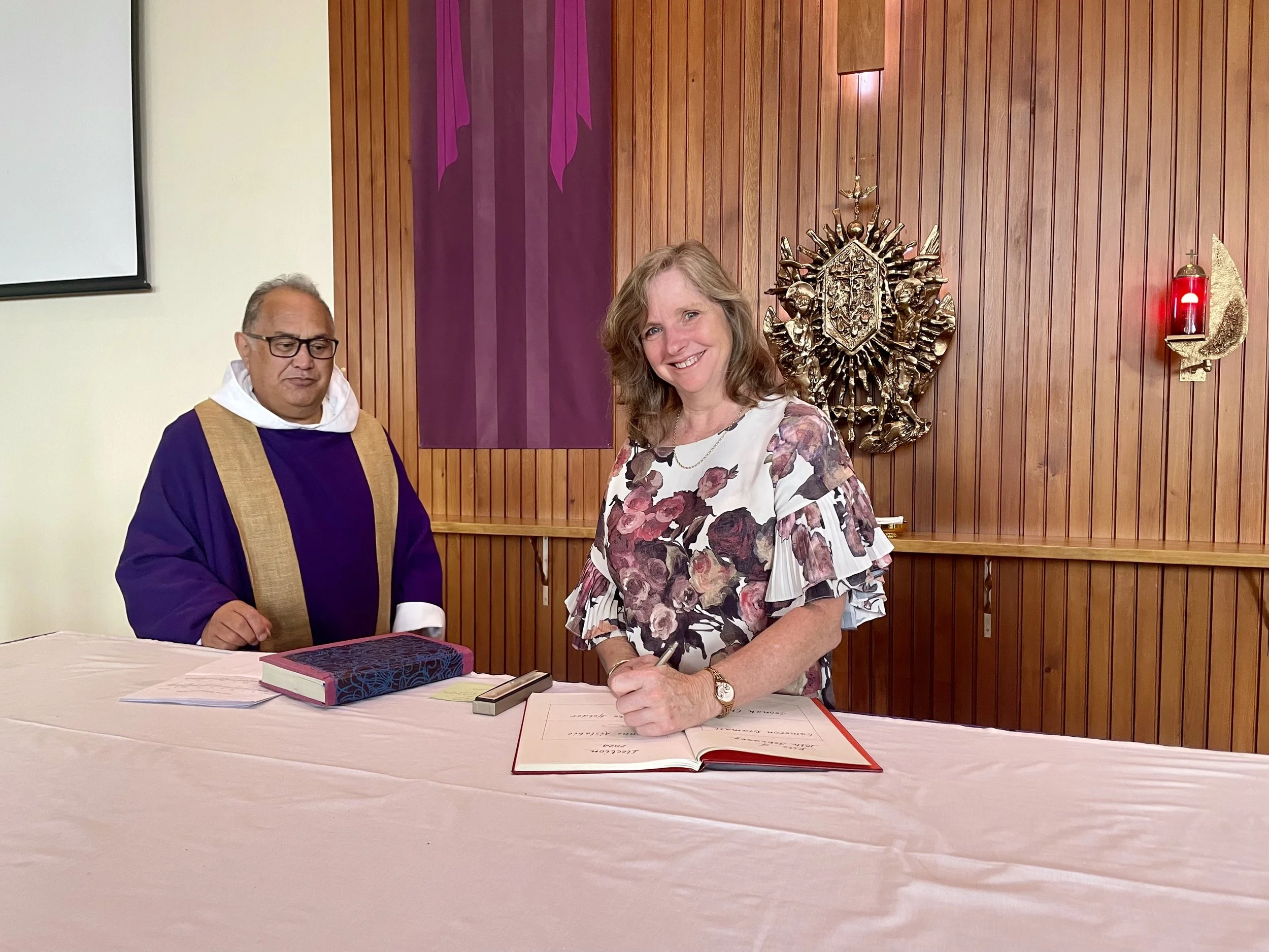 Suzy signing the Book of the Elect
