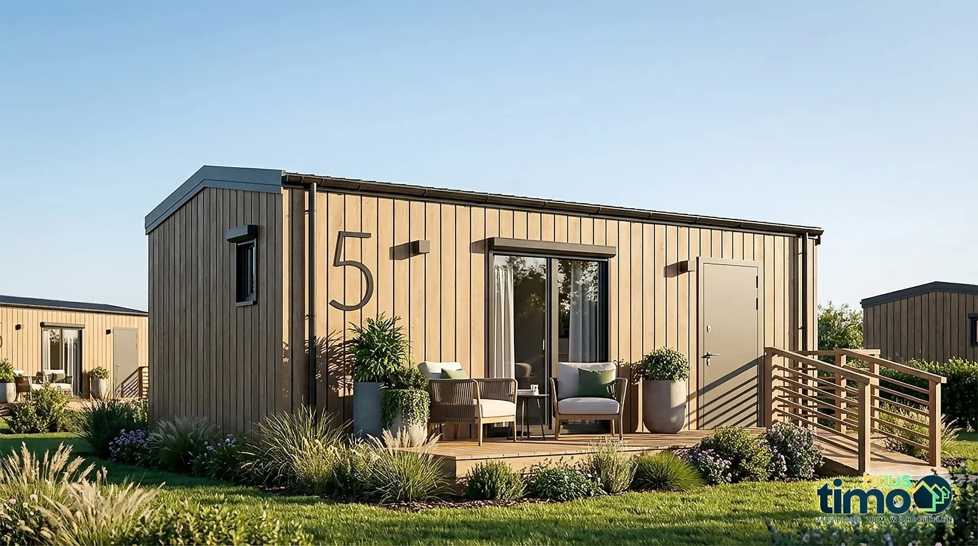 Haus MV25-2 — Außenansicht mit heller Holzfassade, Hausnummer 5, überdachter Terrasse mit Rattansesseln und zweiter Einheit im Hintergrund (Foto: TIMO Haus)