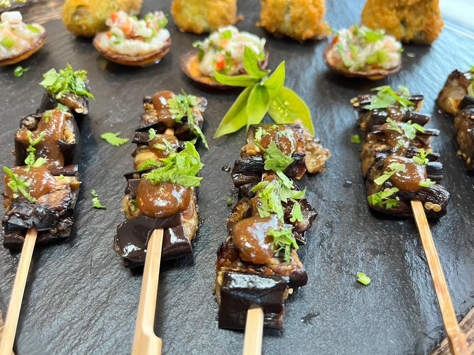 Canapé skewers lined up on slate for a celebration aperitivo in Mallorca