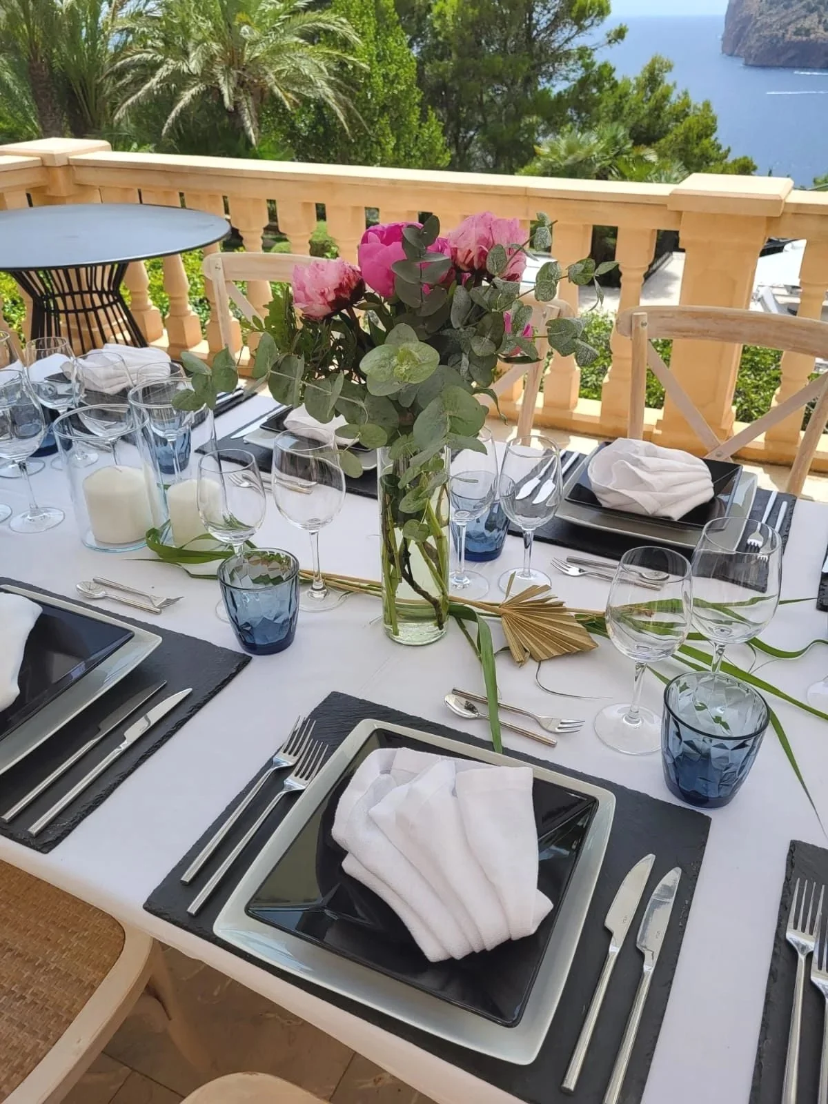 Roses, candles and blue glassware on a celebration table set by Bluelime Bespoke in Mallorca