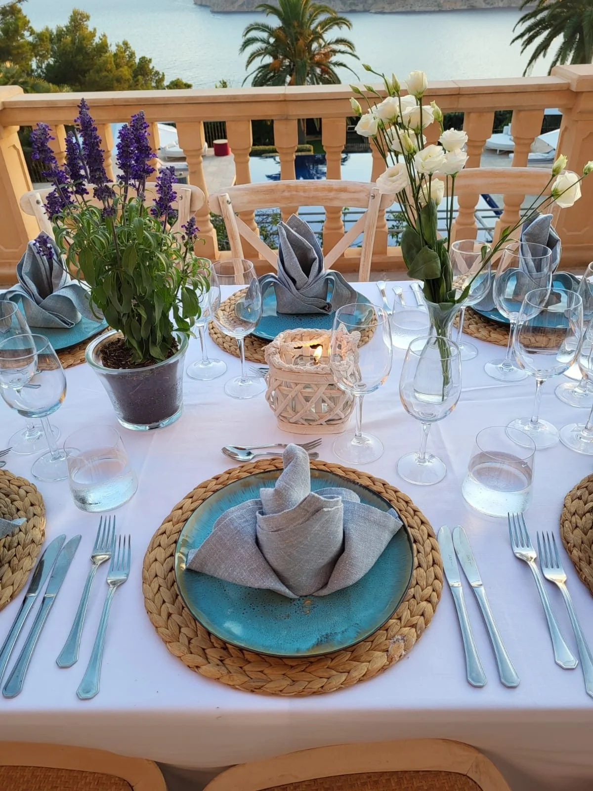 Lavender centrepieces, candle votives and rattan chargers on a candlelit celebration table in Mallorca