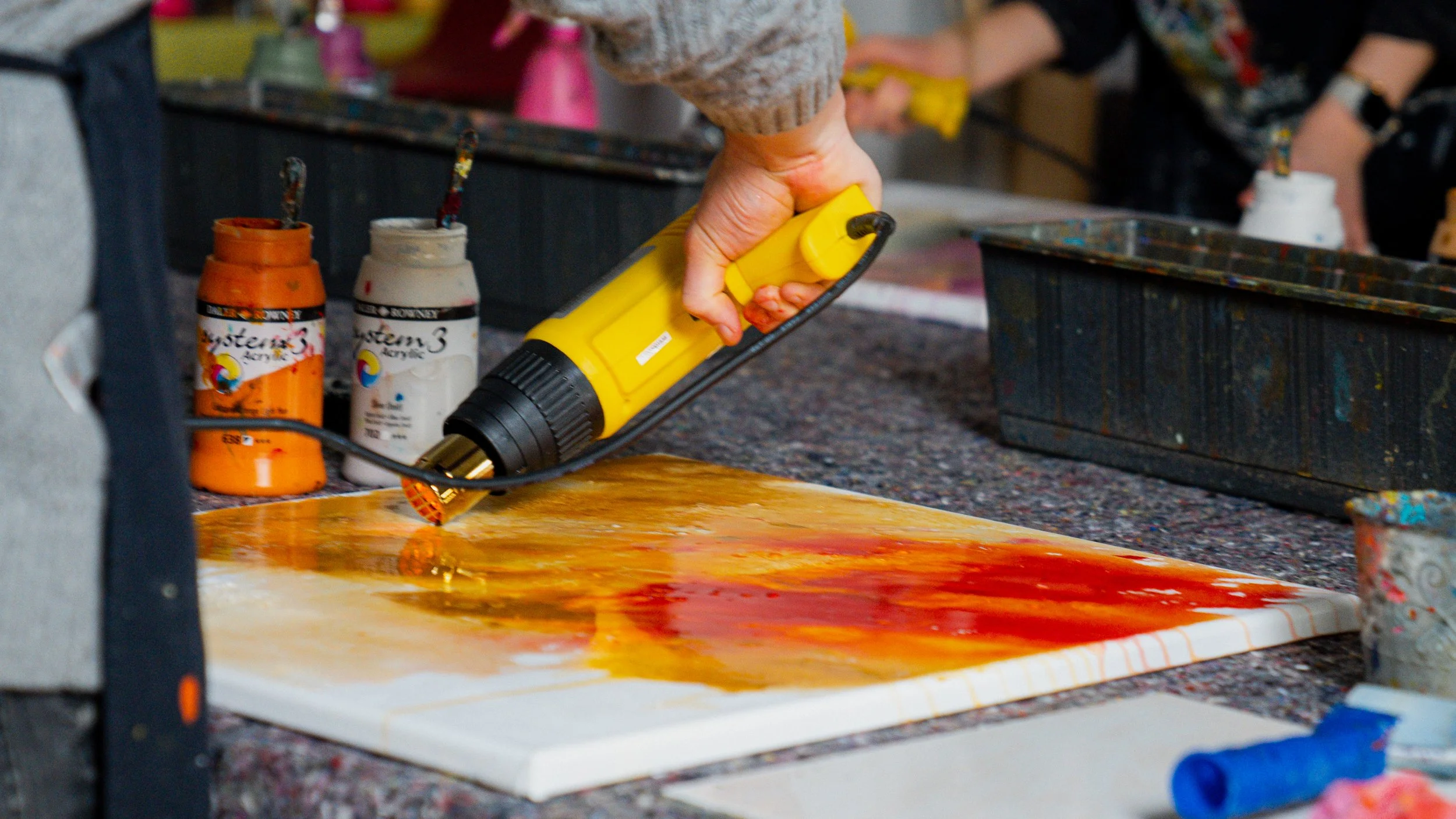 Künstler verwendet Heißluftgebläse auf Leinwand