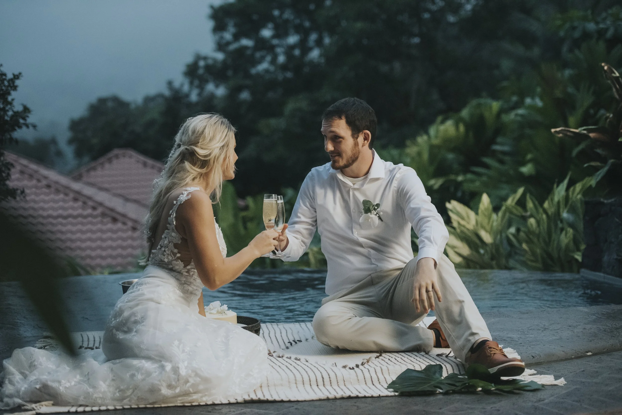 Couple celebrating their union with a toast by the Arenal Volcano, capturing the majestic backdrop and the joy of a tropical wedding.