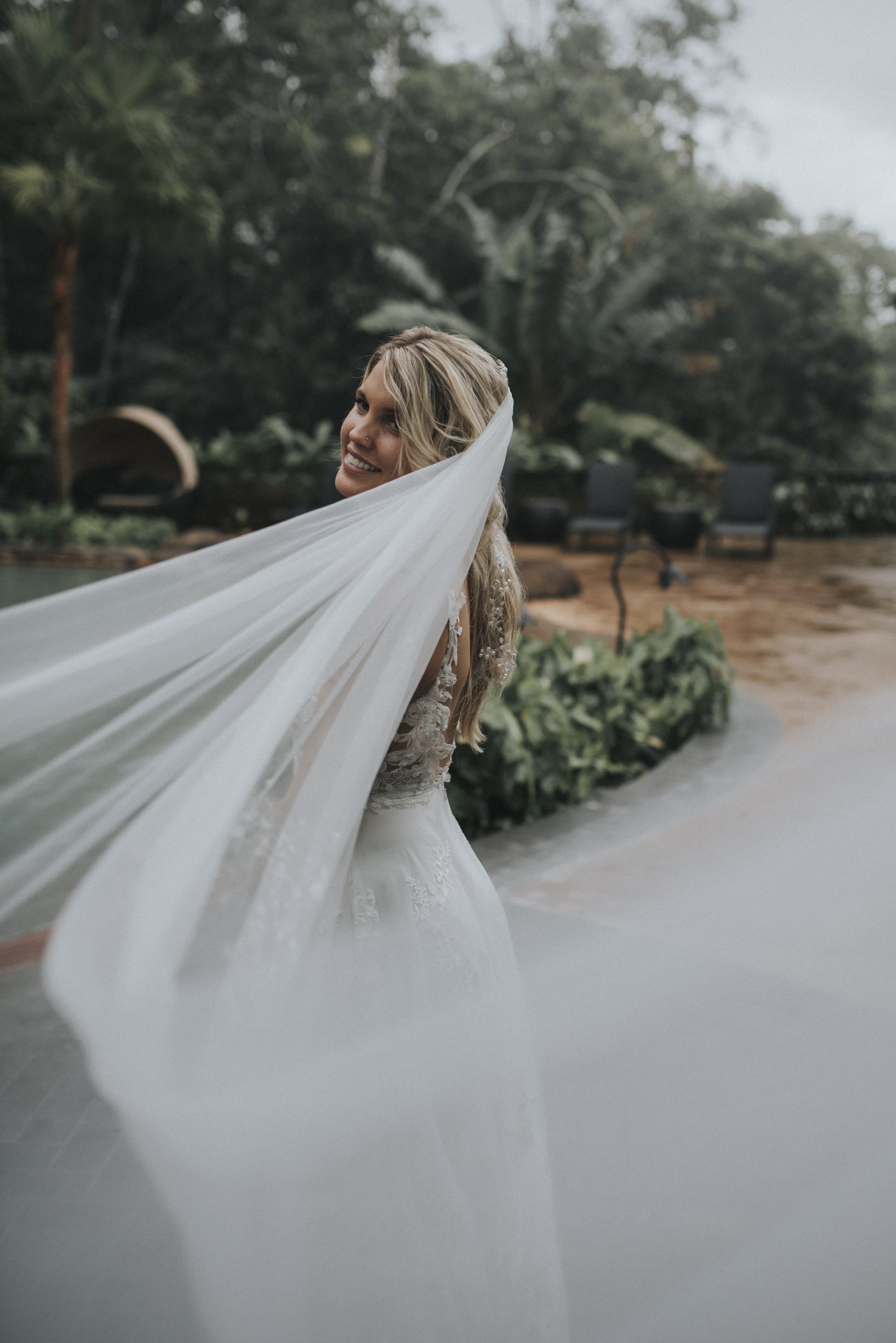 The bride’s flowing veil dances in the breeze as they share quiet, cherished moments