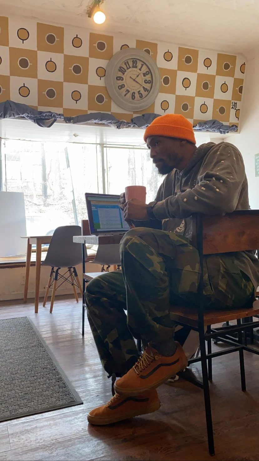 chaz thomas sitting in a cafe drinking coffee