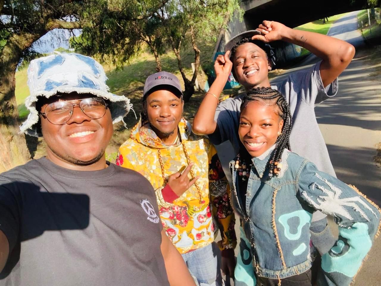 Inspiring Better Learning Brighter Futures youth&mdash;Chris, Kennedy II, and Anna&mdash;posing in Tevin's latest handmade fashion creations to promote DTCare's first-ever collaboration with With Us By Us for the Not Just A Party fundraiser. 🙌🇿🇦 
