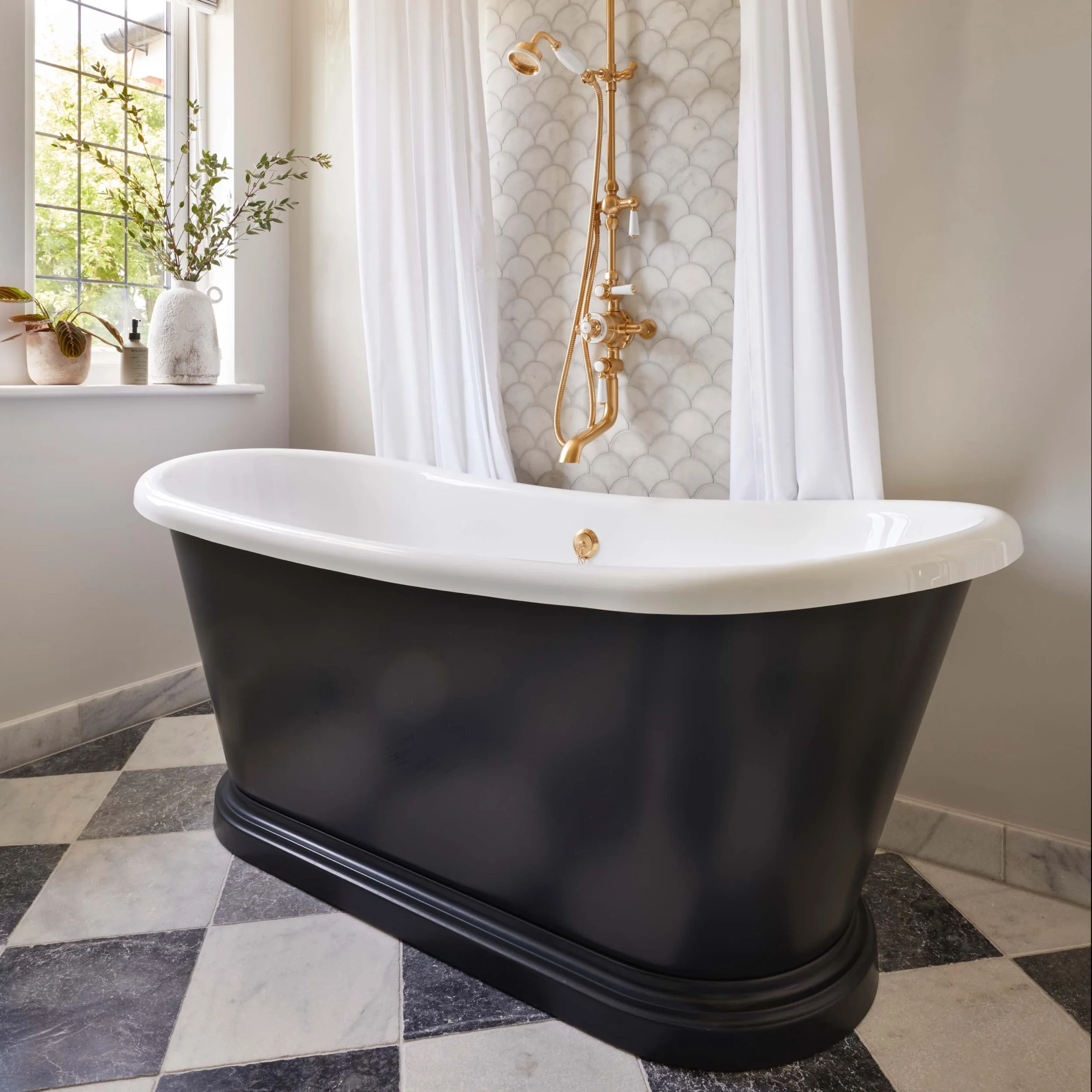 black boat bath with white edging in front of scallop white tiling
