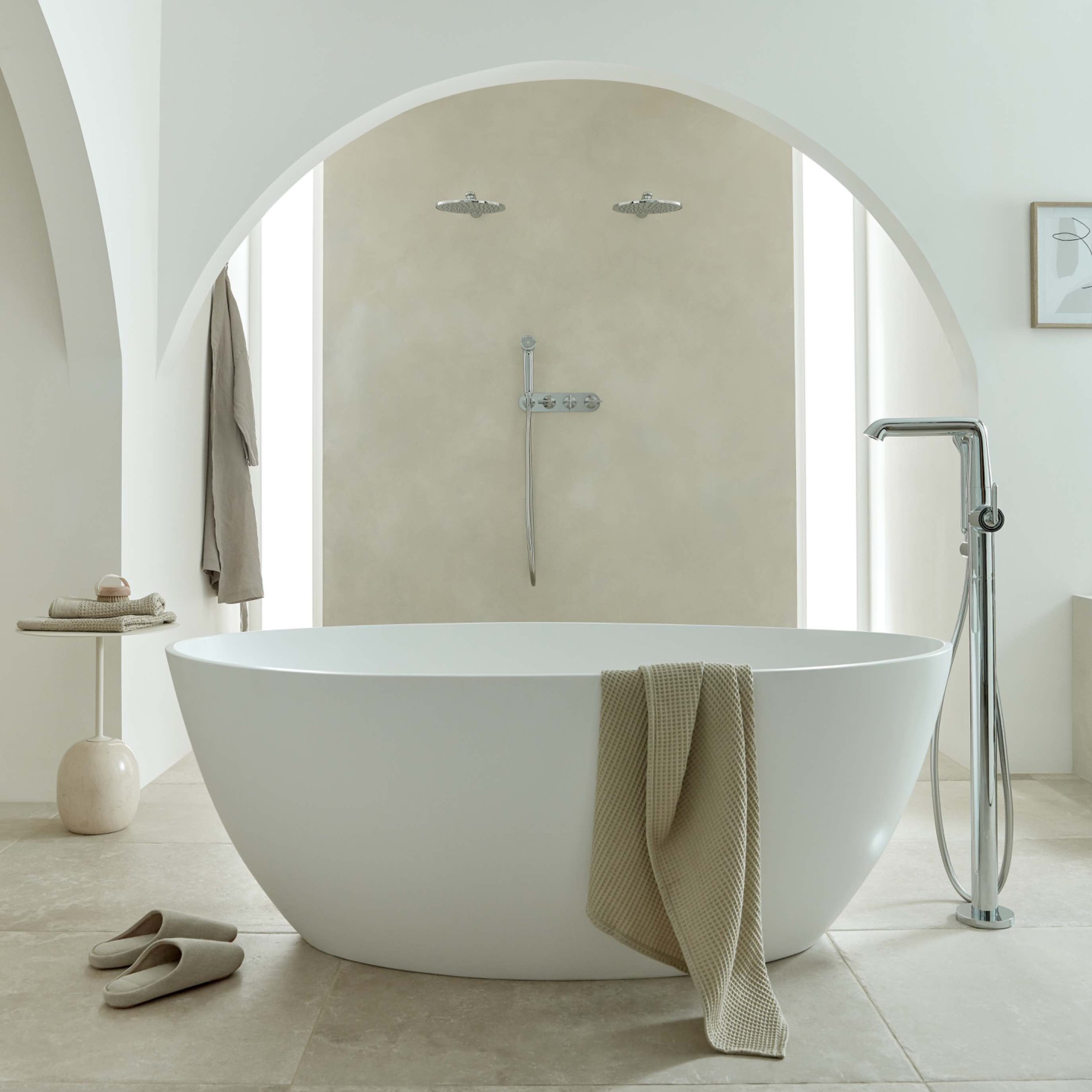 white bath in a bathroom with an arched doorway with a towel over the bath.