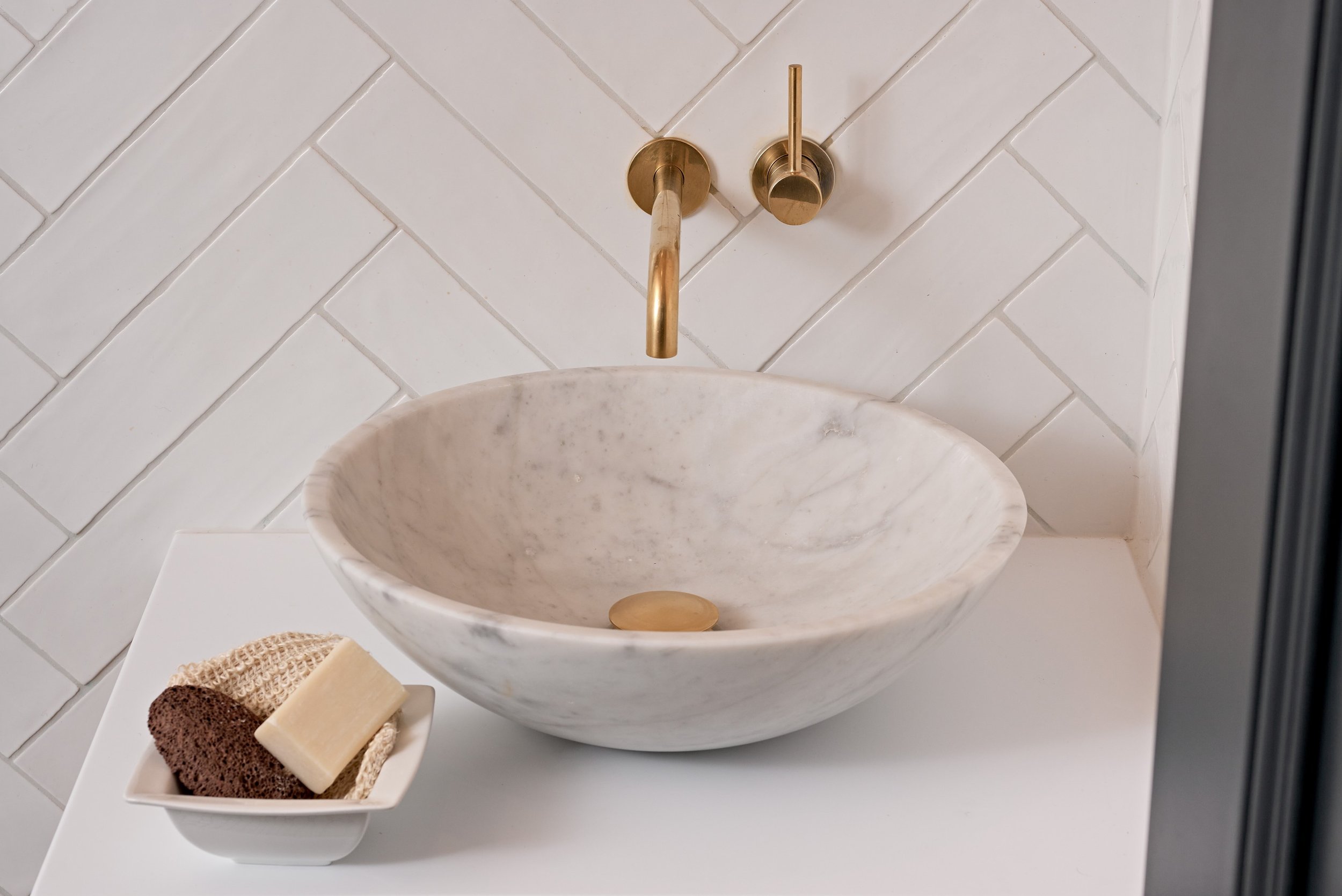 top down view of marble basin with gold brassware