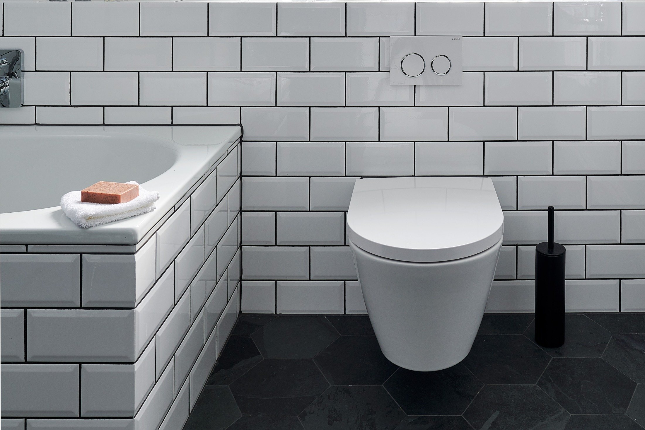 wall hung wc in bathroom with white metro tiles and hexagonal floor tiles