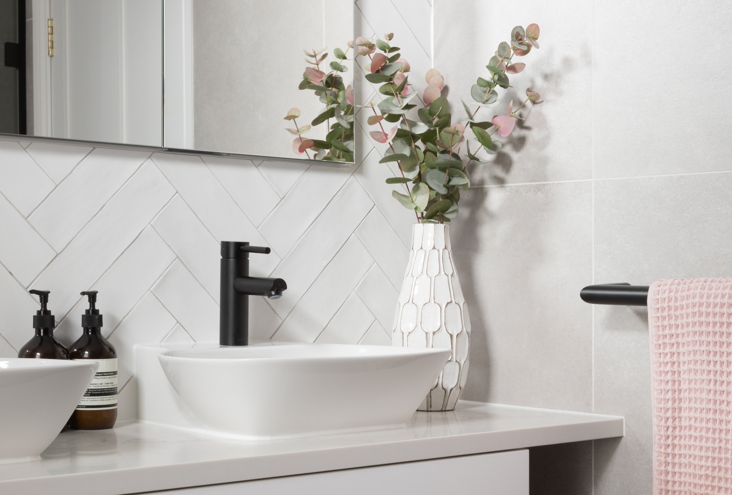 white basin with black brassware and euclayptus