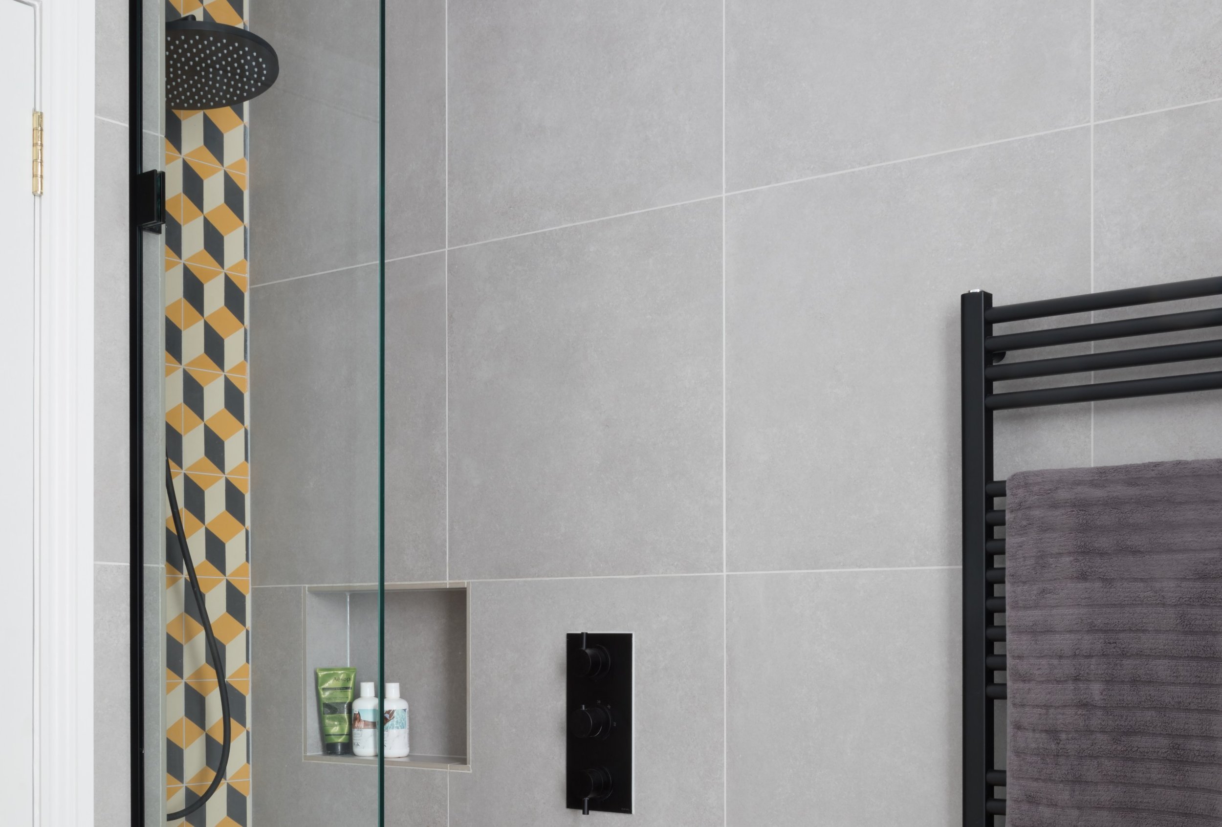 black shower with grey tiles and black radiator