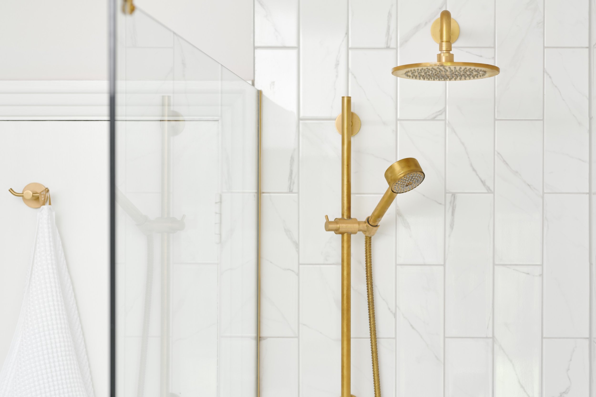 gold-shower-with-marble-metro-tiles.jpg