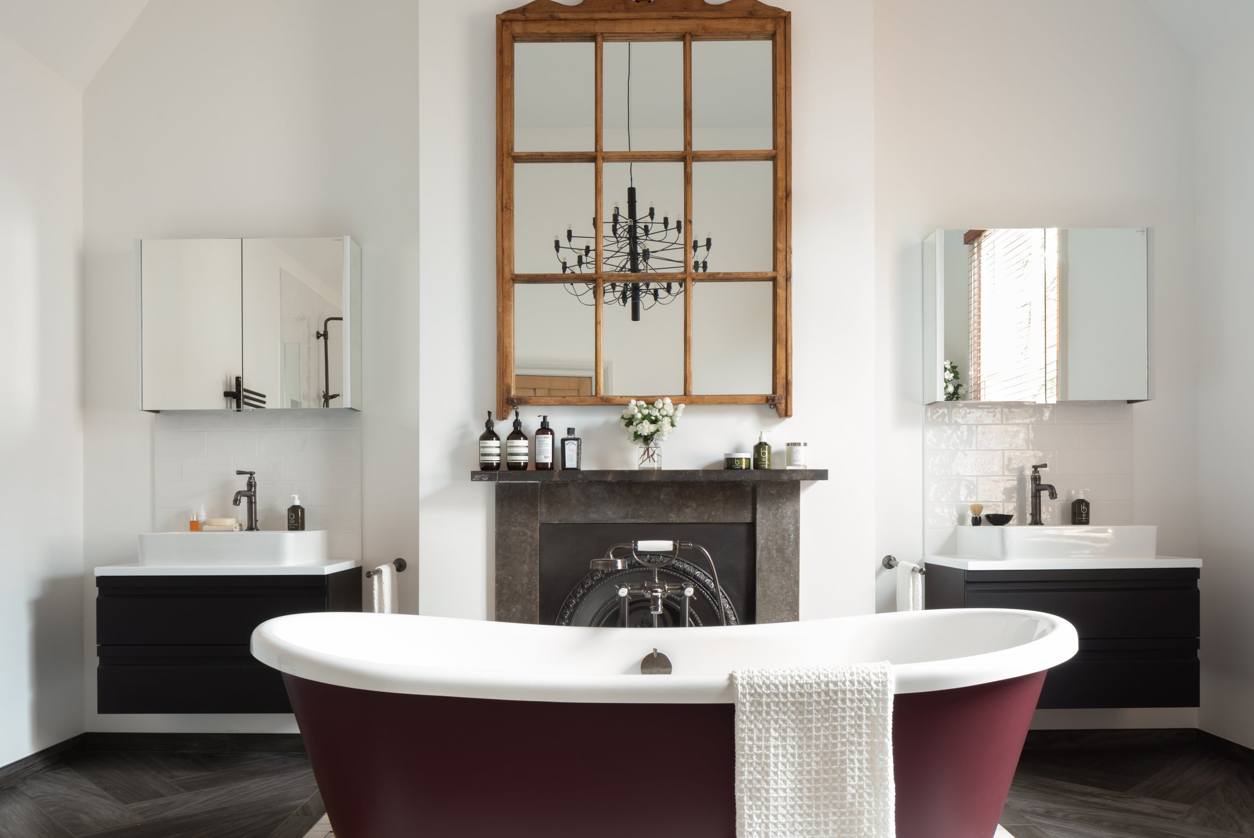 berry-coloured-rolltop-in-bathroom-with-black-chandelier.jpg