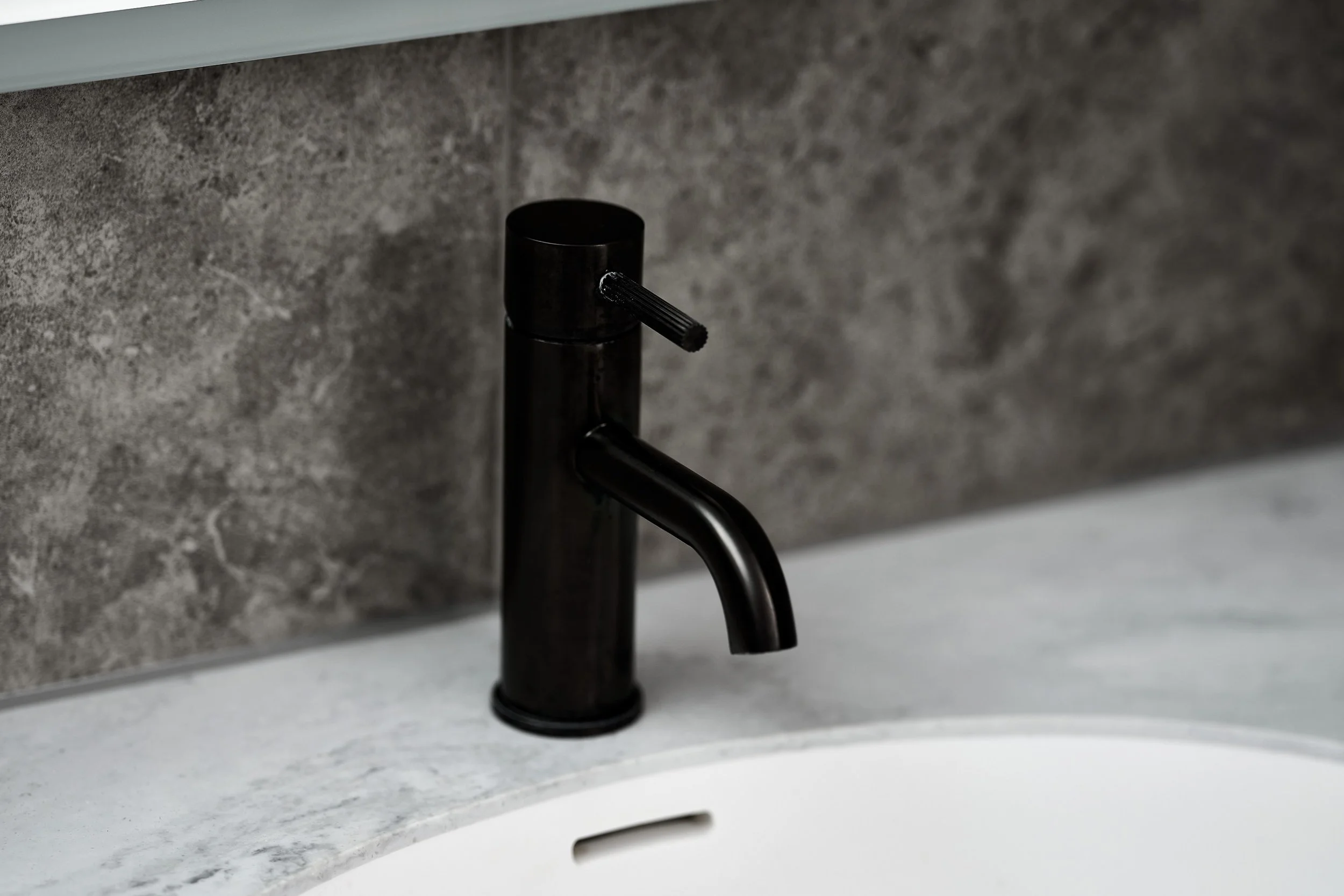 close-up-gun-metal-finish-tap-in-ripples-bathroom.jpg
