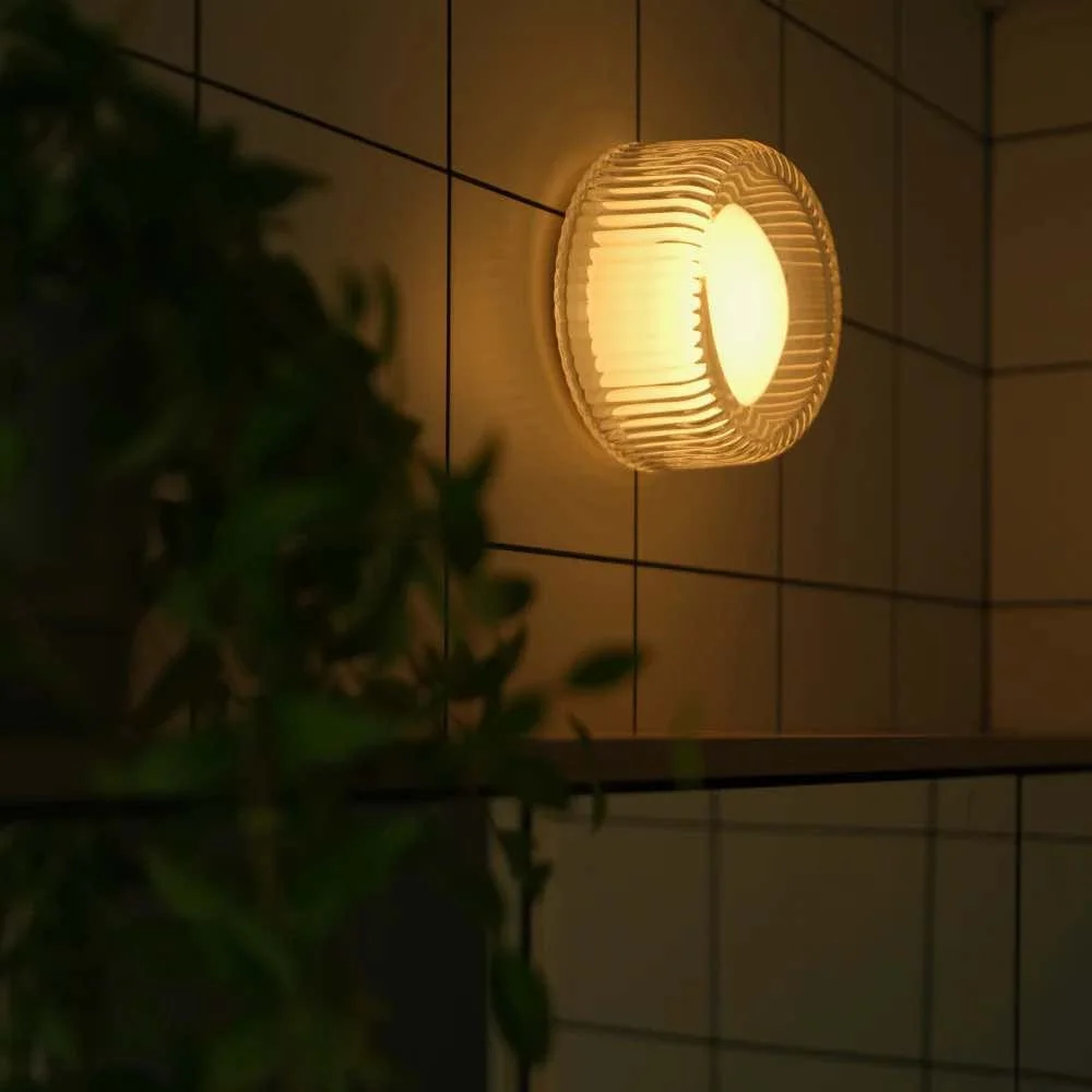 died bathroom close up on vanity mirror with small round ribbed light above it.