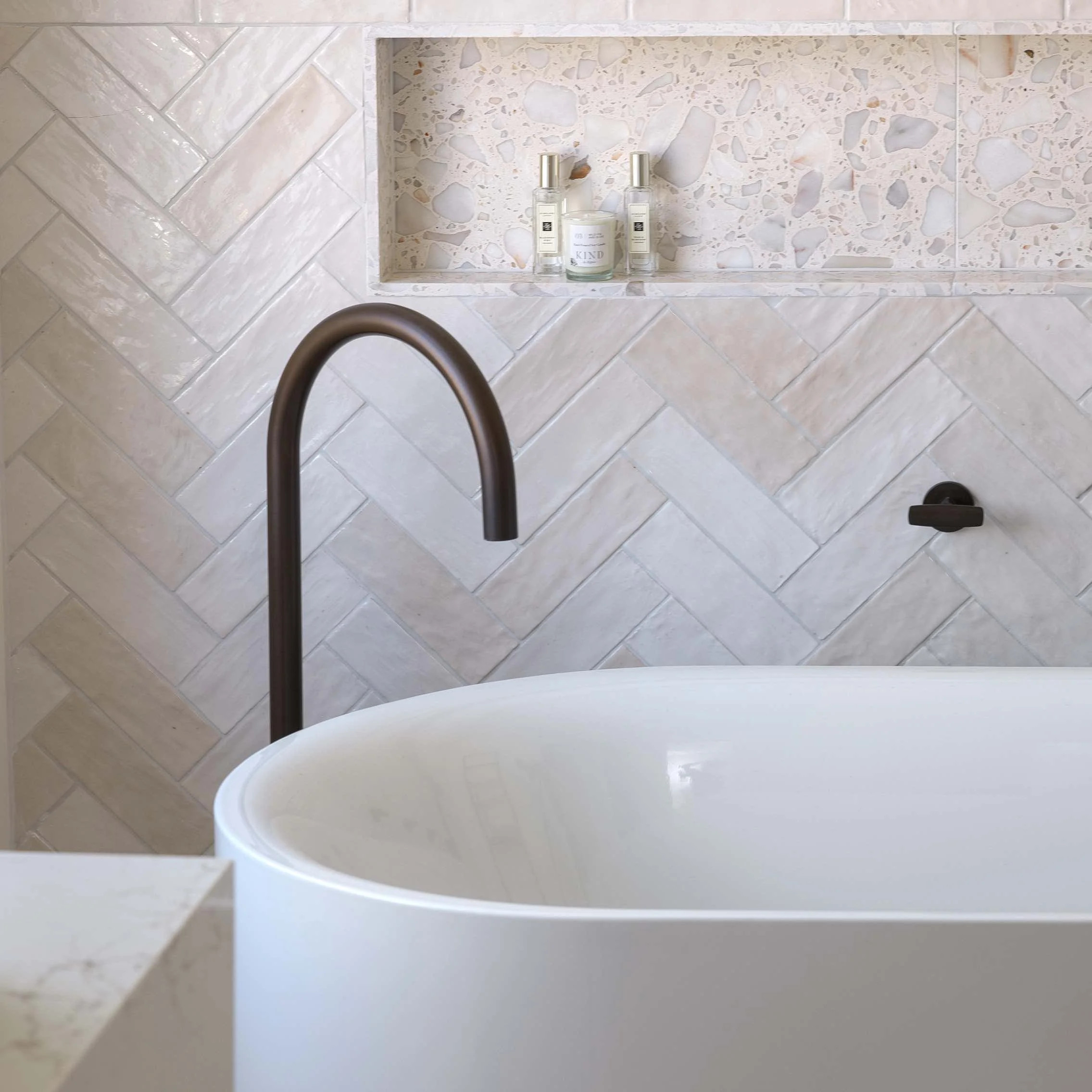 Dark bronze freestanding bath spout over freestanding white bath