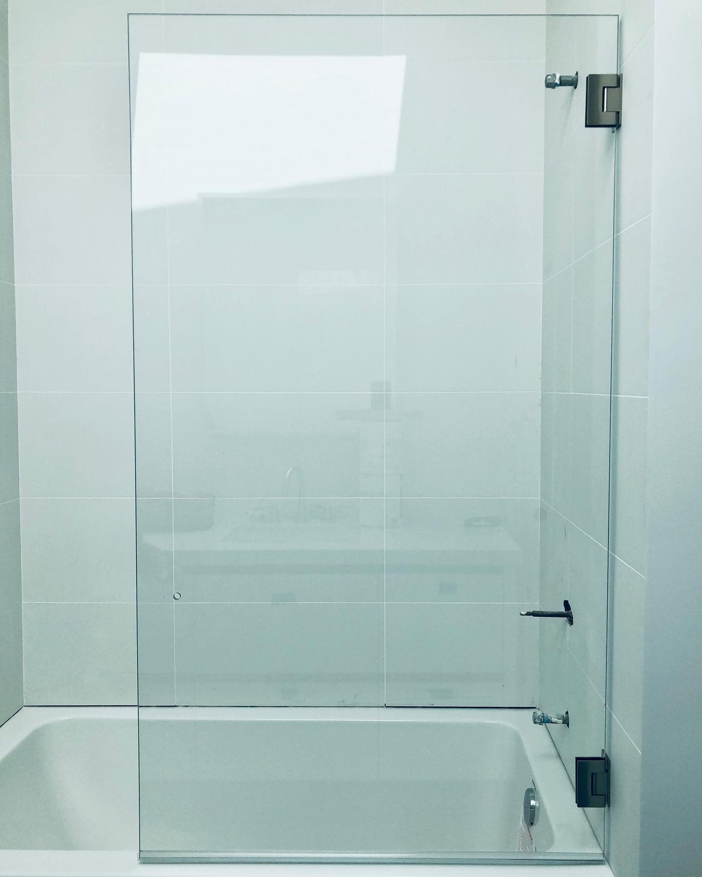 1/2-inch StarPhyre (low iron) hinged partition with brushed nickel hardware in Malibu, CA. This minimalist design looks elegant and allows the user to open it to turn on the water. Call 805.300.0721 today to start your next glass and mirror project!
