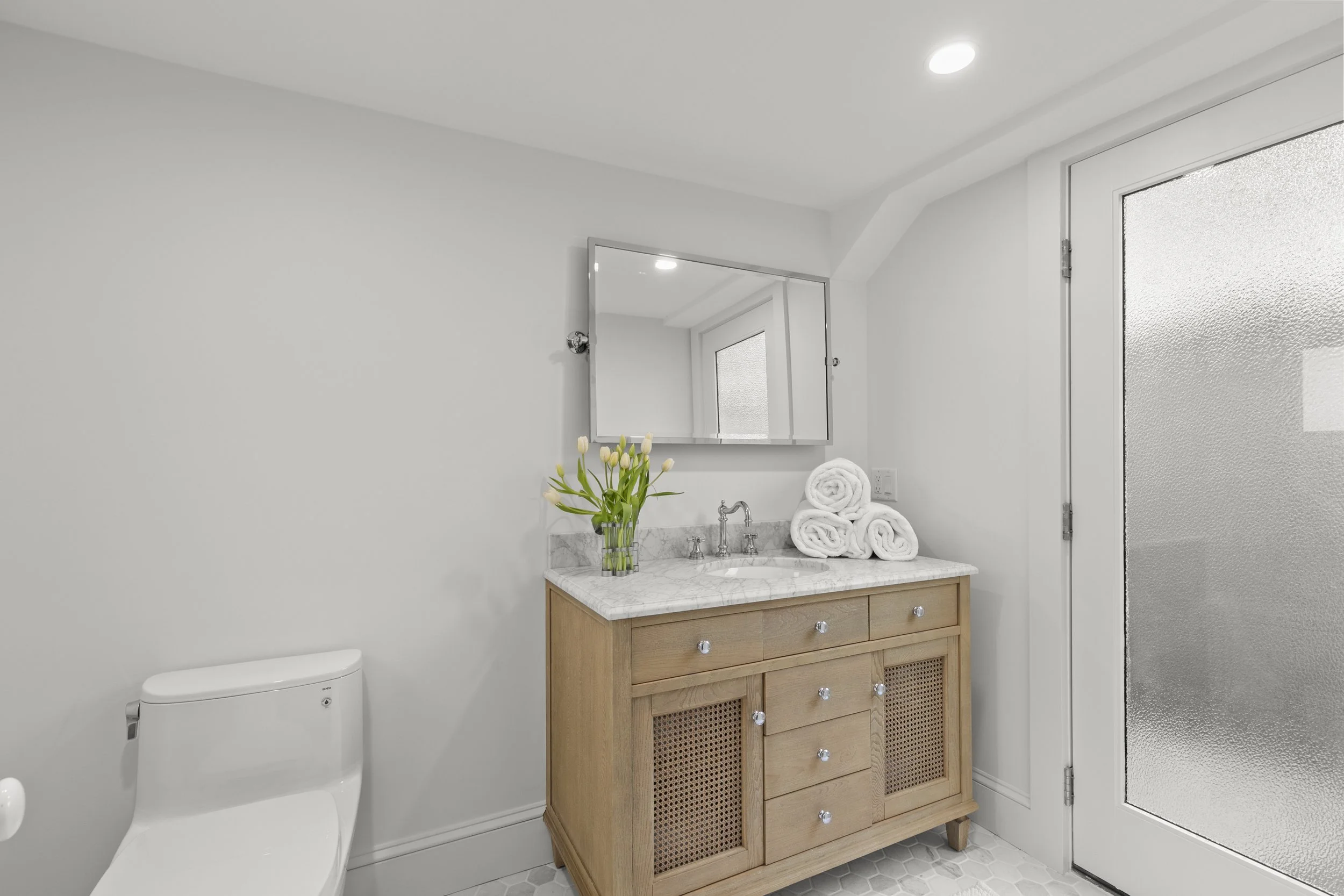 Full view of half bathroom with extra towels and access to outdoor shower