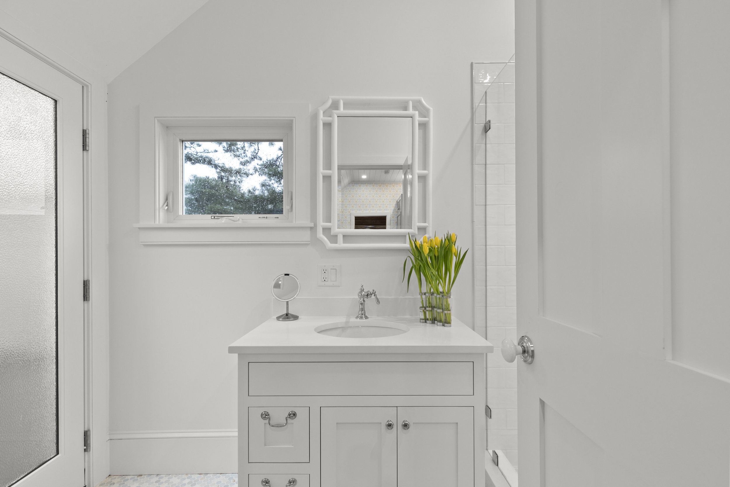View of the sink and mirror in full bathroom