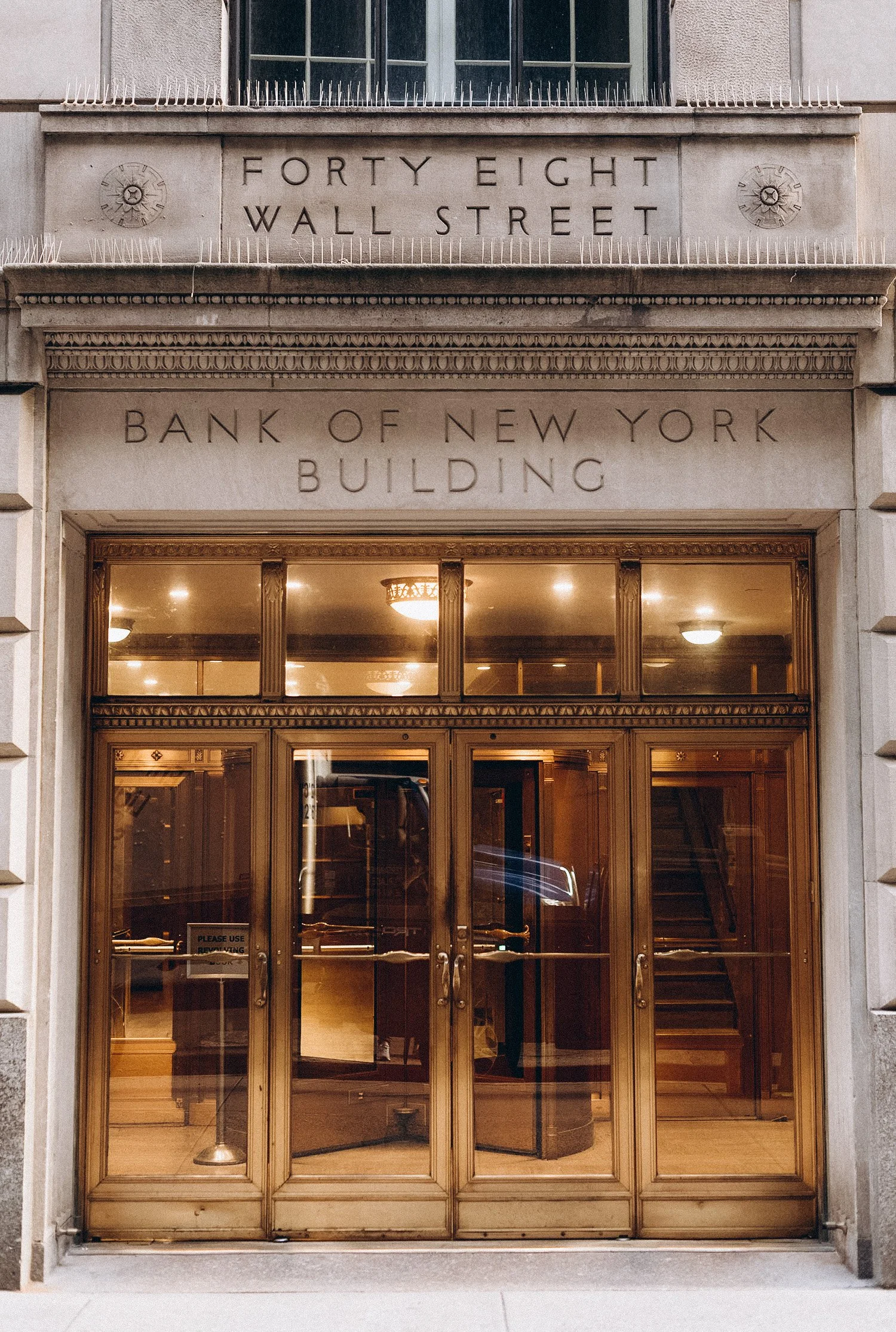 Entrance of the Bank of New York building with a sign for Forty Eight Wall Street above the door.