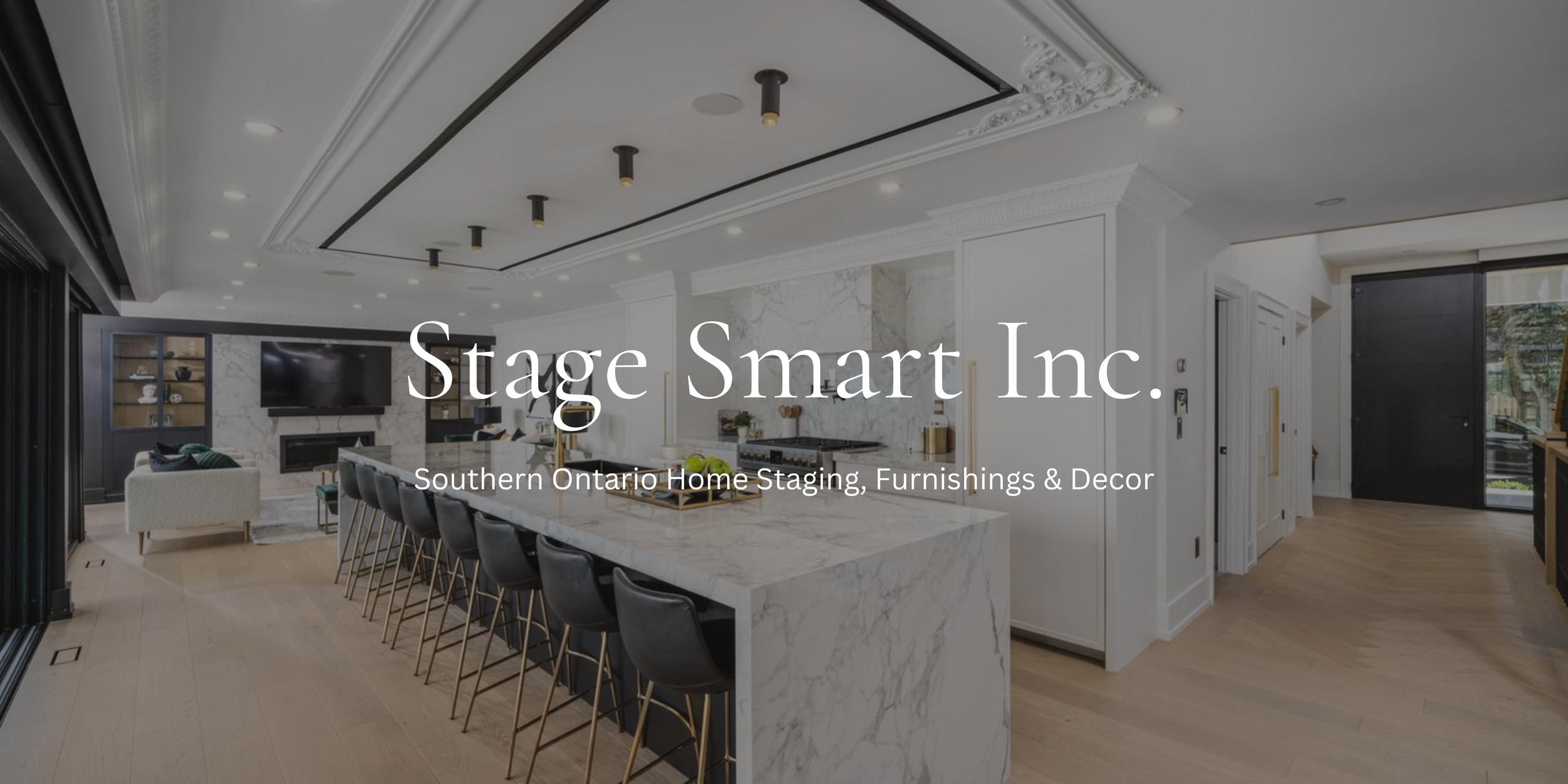 Modern living room with white marble fireplace, televisions, black chairs at a white marble kitchen island, and black sliding door leading outside.