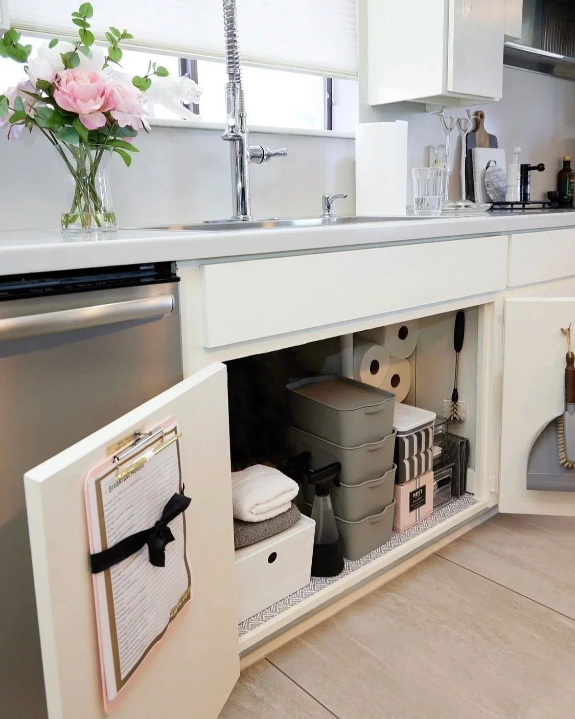 Organized kitchen storage with open drawer beside a modern kitchen sink
