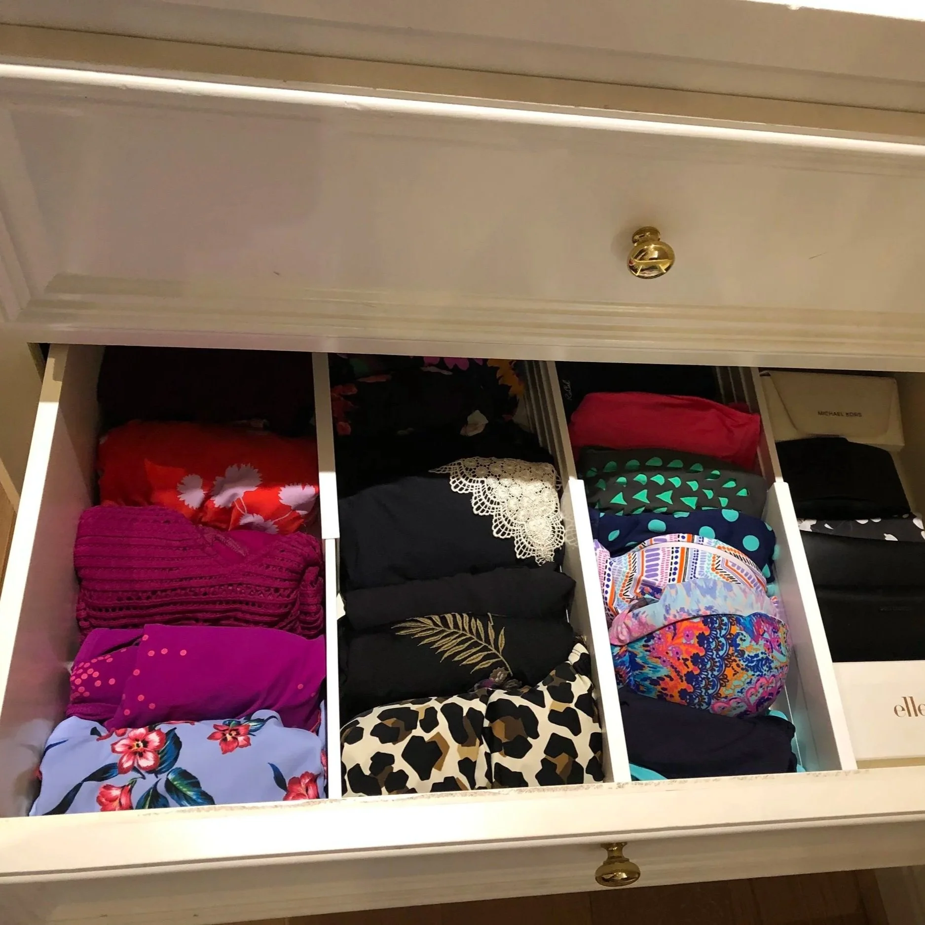 Neatly folded swimwear separated by drawer dividers.