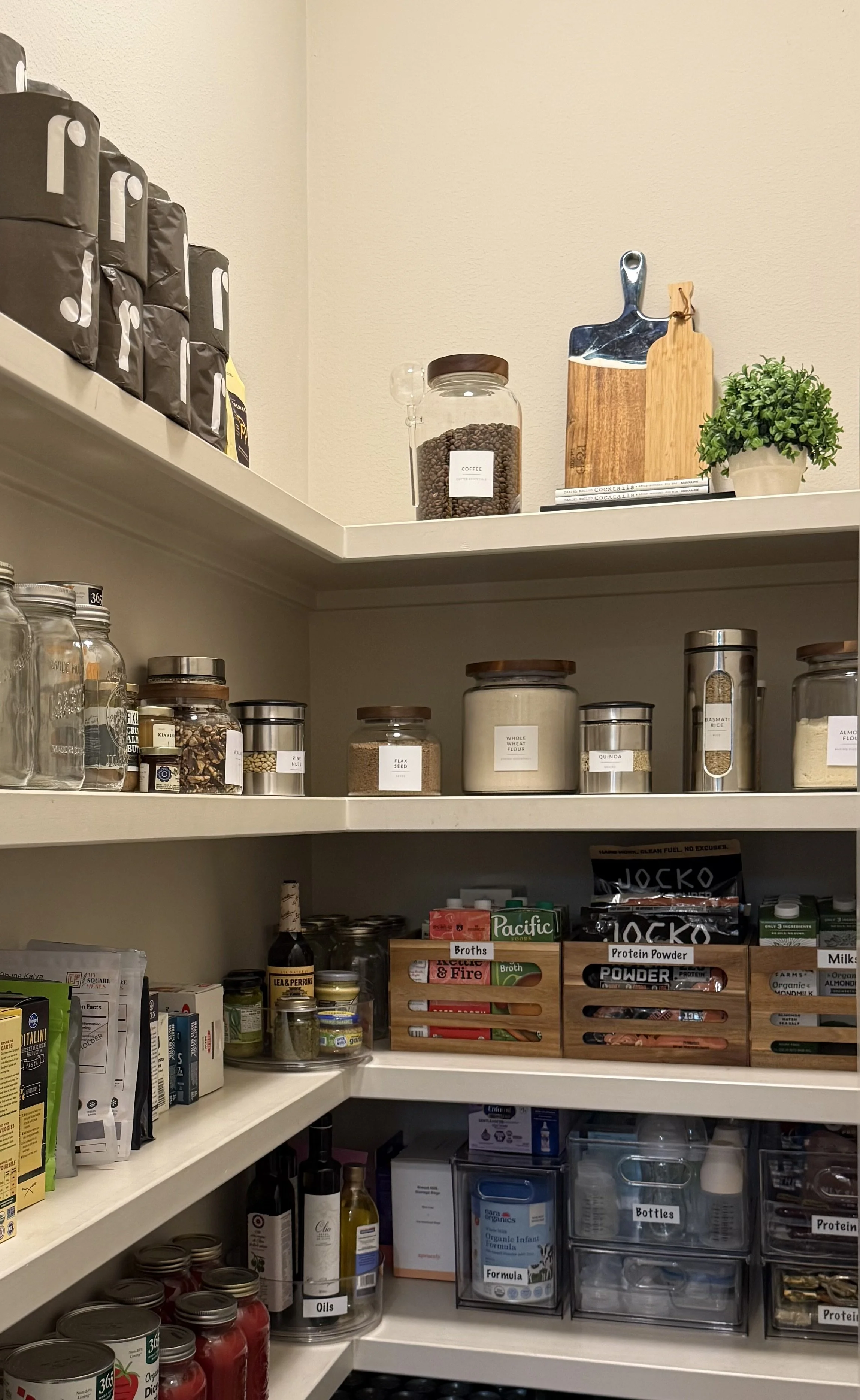 Luxury walk-in pantry in River Oaks, Houston by Luxury Pro Organizer with clearly labeled containers in functional categories, creating a beautiful, efficient storage system that elevates everyday living.