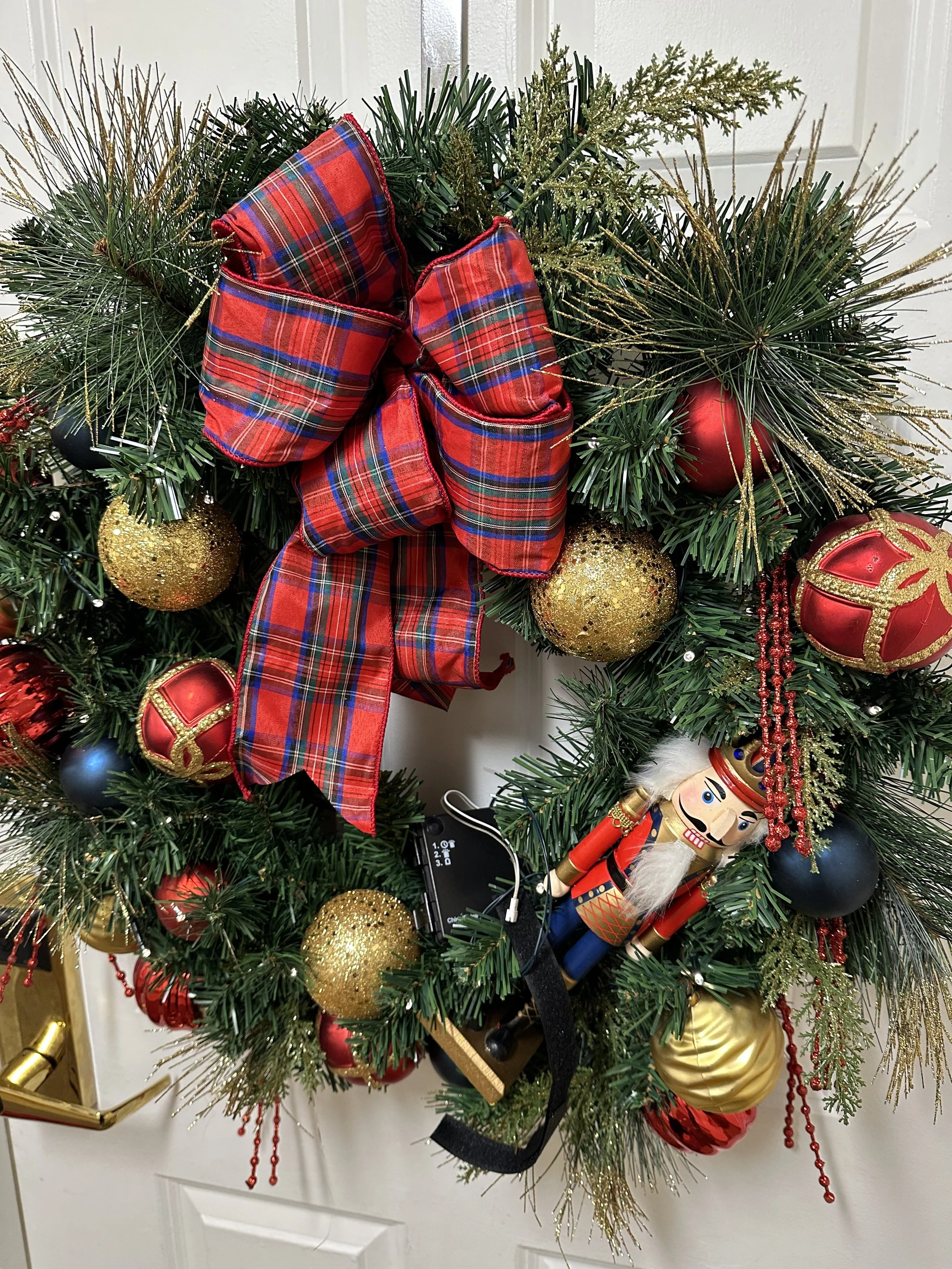 Christmas Wreath with Gold and red ornaments and a nut cracker soldier in the wreath decorations