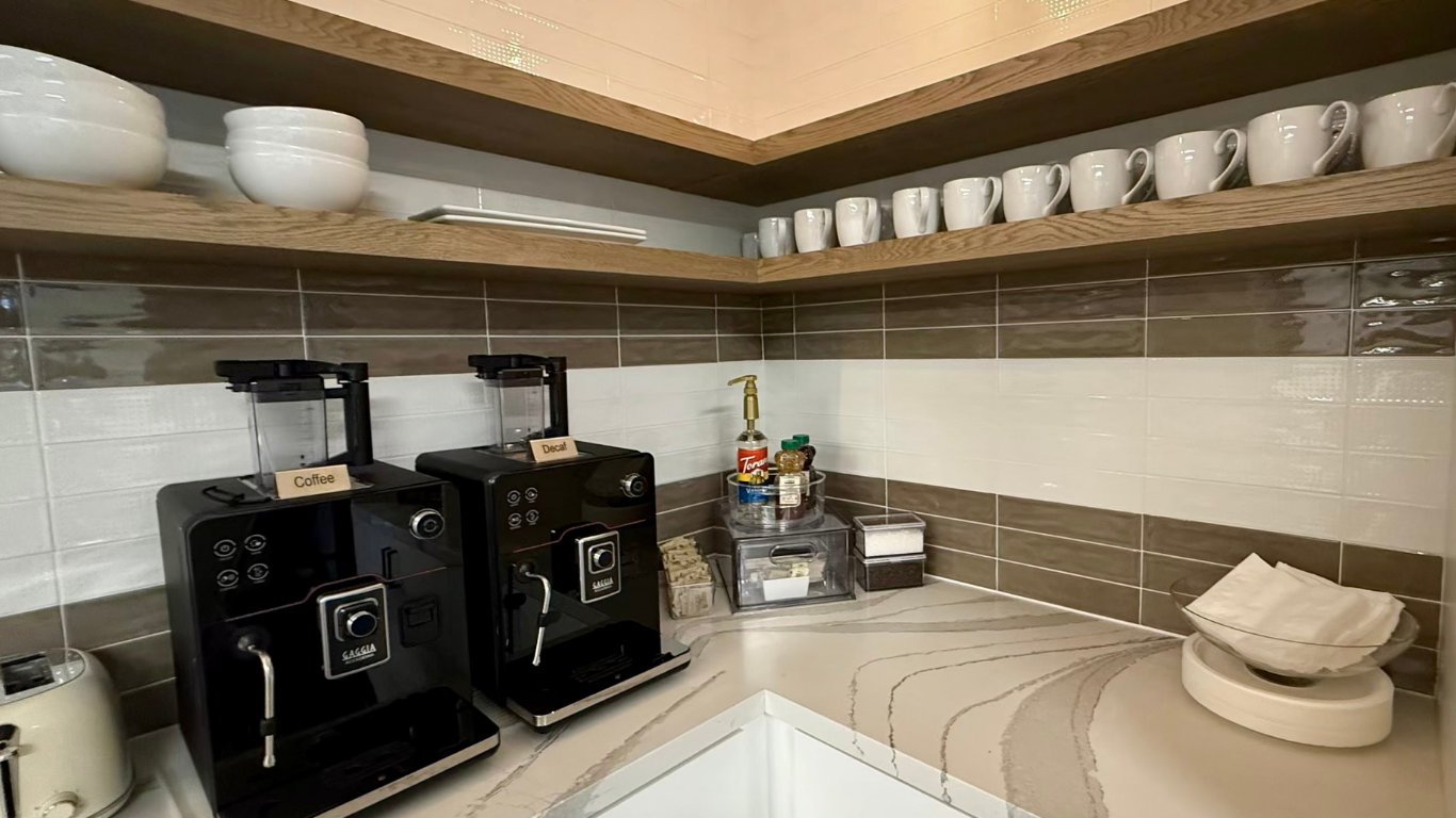 Corporate coffee station with coffee machines and cups arranged on a countertop.