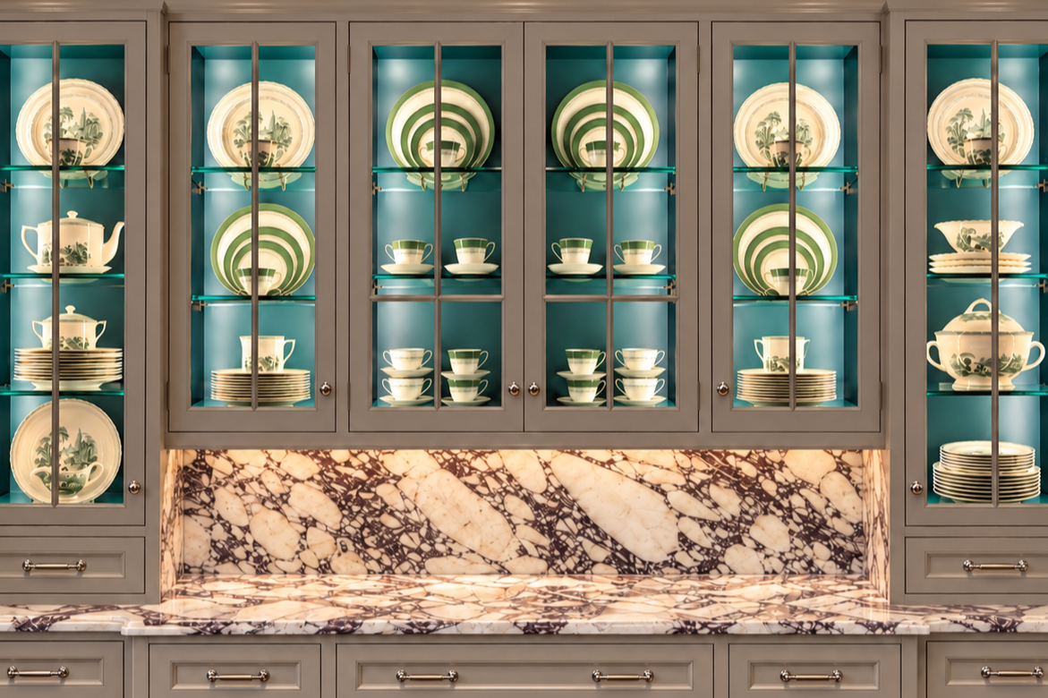 Serving platters and bowls arranged in a kitchen cabinet by Luxury Pro Organizer.