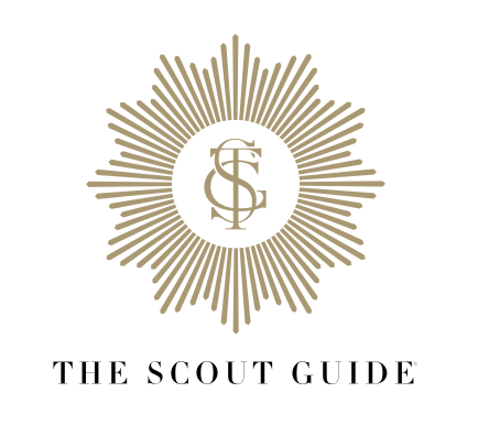 Logo for The Scout Guide featuring a gold sunburst design with the initials 'SG' in the center and the text 'The Scout Guide' below.