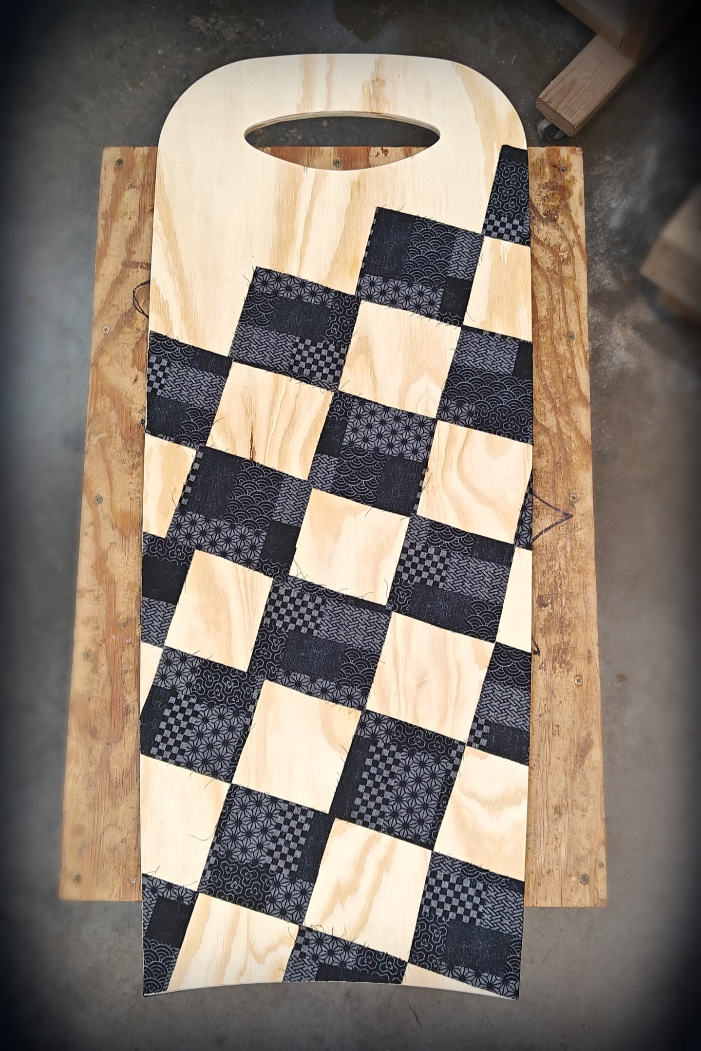 Hand-made itago board, made from wood with a black Japanese textile quilt-like pattern overlayed.