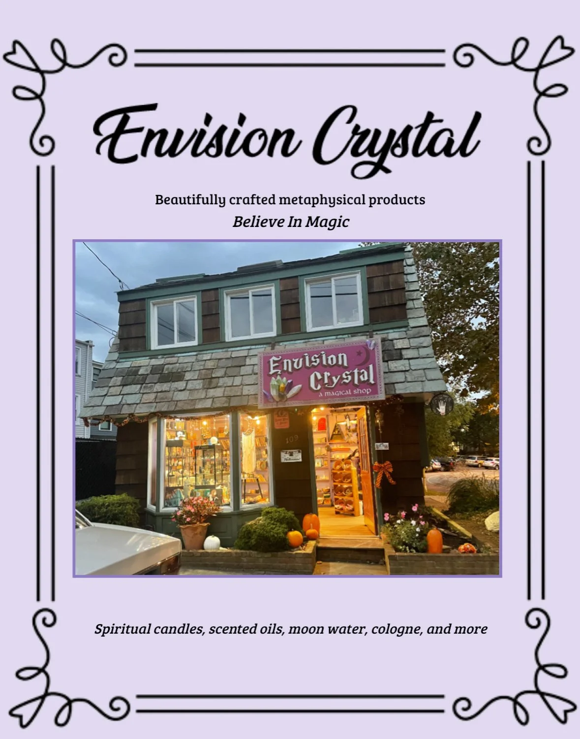 Photo of a small, two-story shop named Envision Crystal with a purple sign, decorated for fall, with pumpkins and plants outside, and lit window display at dusk.