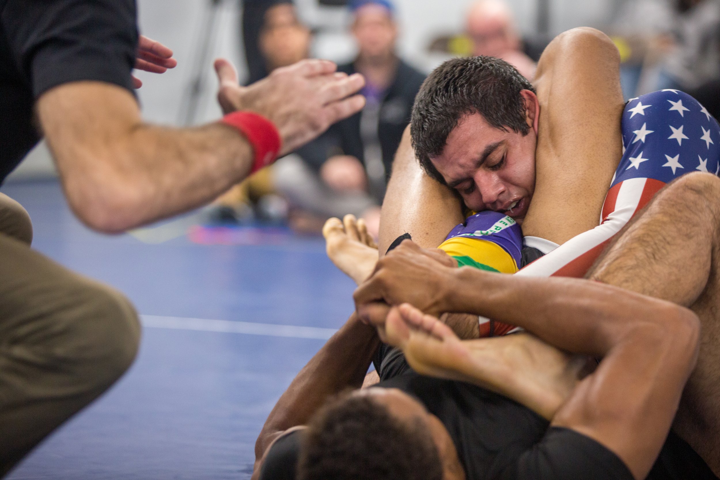 The referee halts the match as a Brazilian jiu-jitsu practitioner submits his opponent via arm bar and triangle.