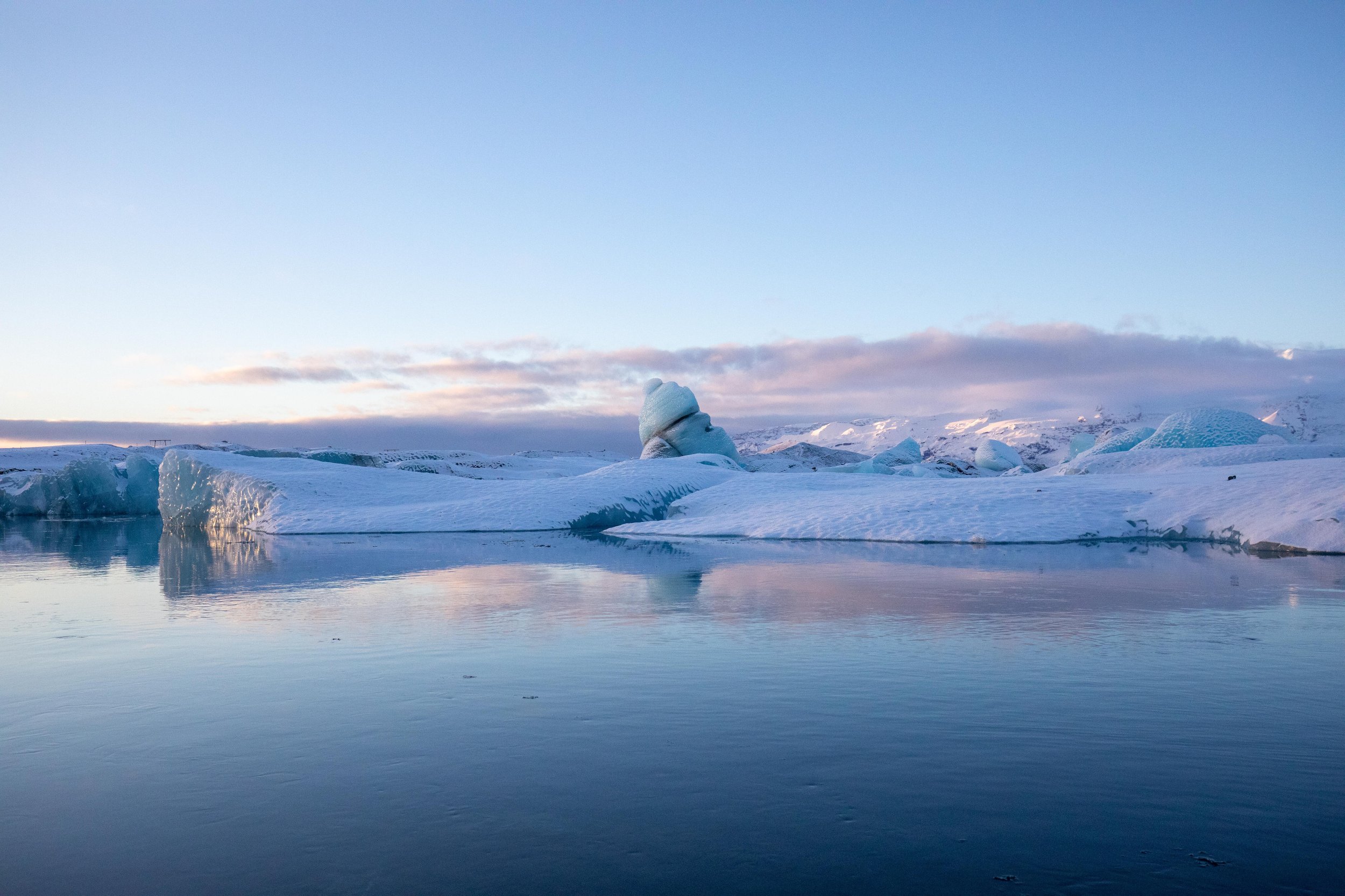 Still waters reflect the ice and sky in Glacier Lagoon, Iceland.