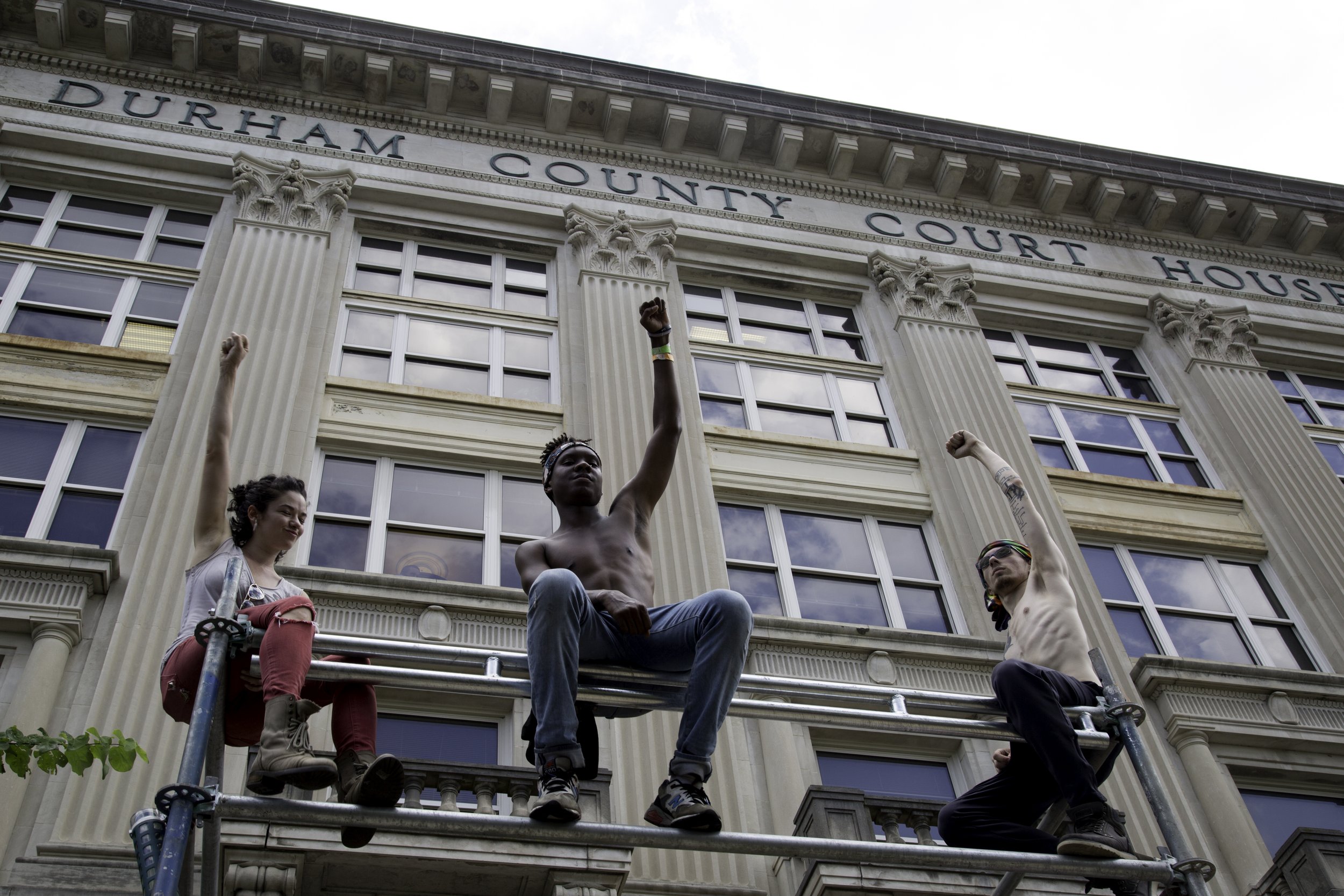 Demonstrators raise Black Power fists outside the Durham County Court House during a demonstration against white supremacy.