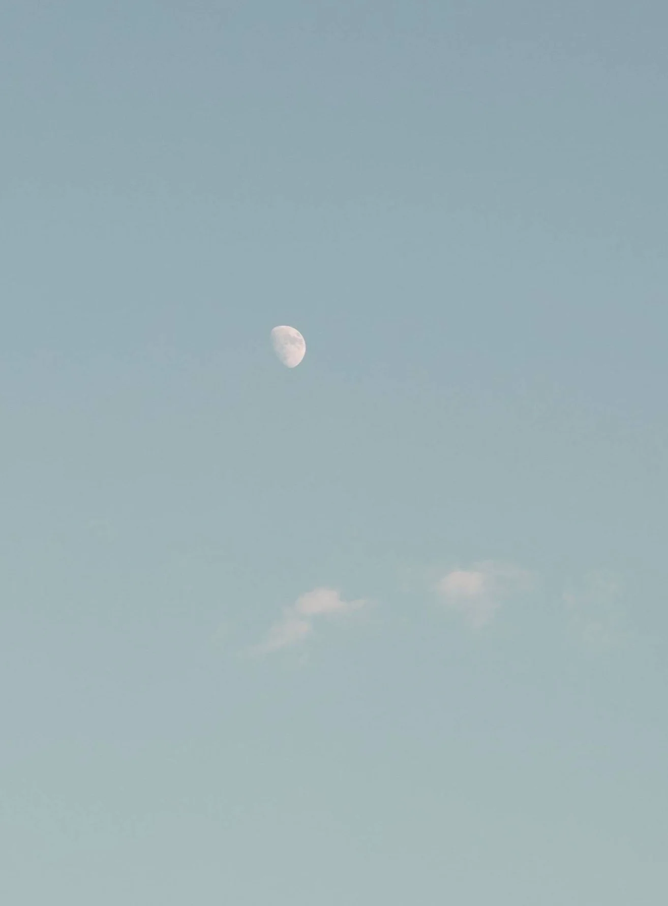 A clear sky with the moon visible, some clouds, and a few wispy clouds near the bottom.