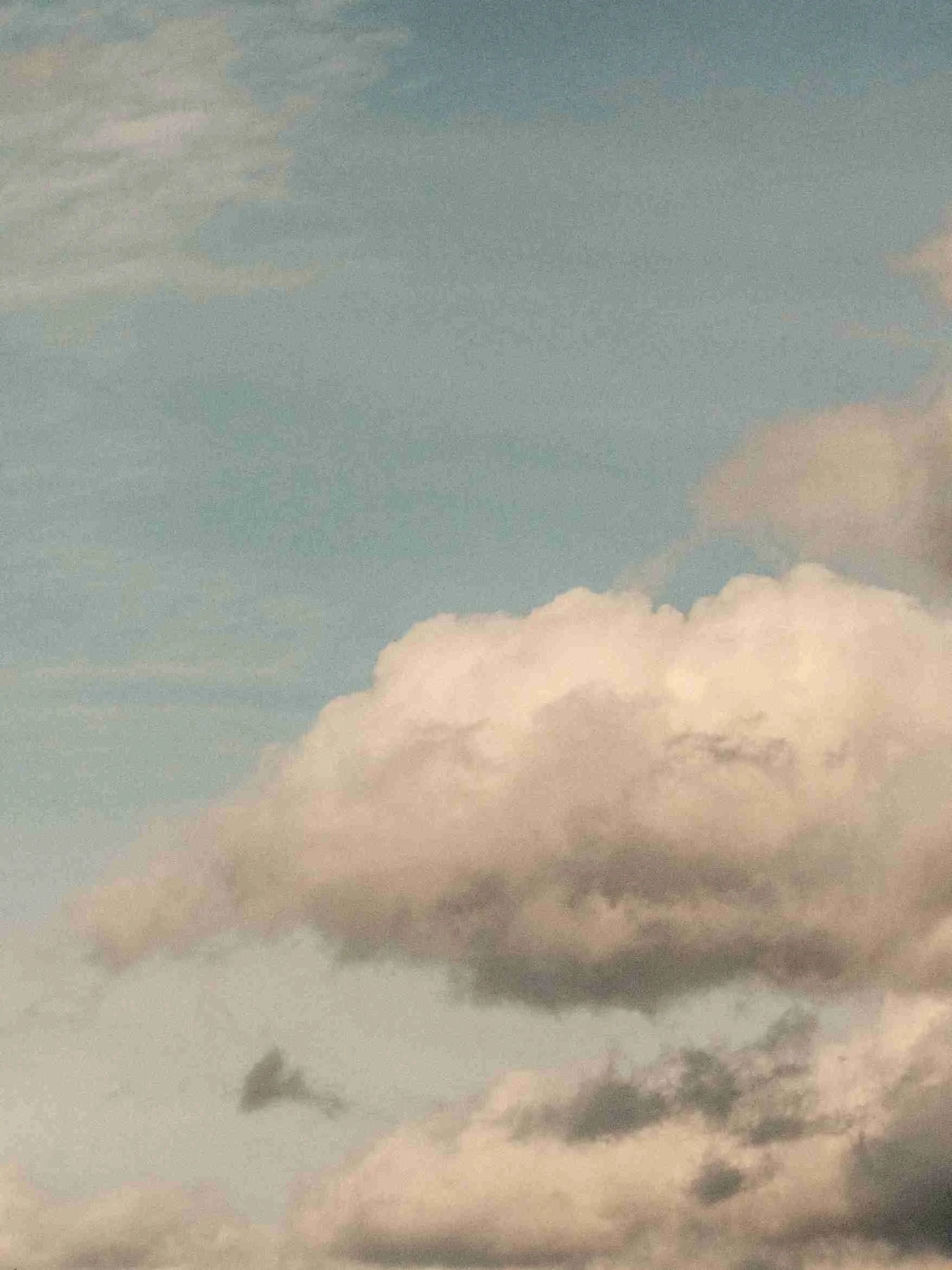 Cloudy sky with dark and light clouds at sunset or sunrise.