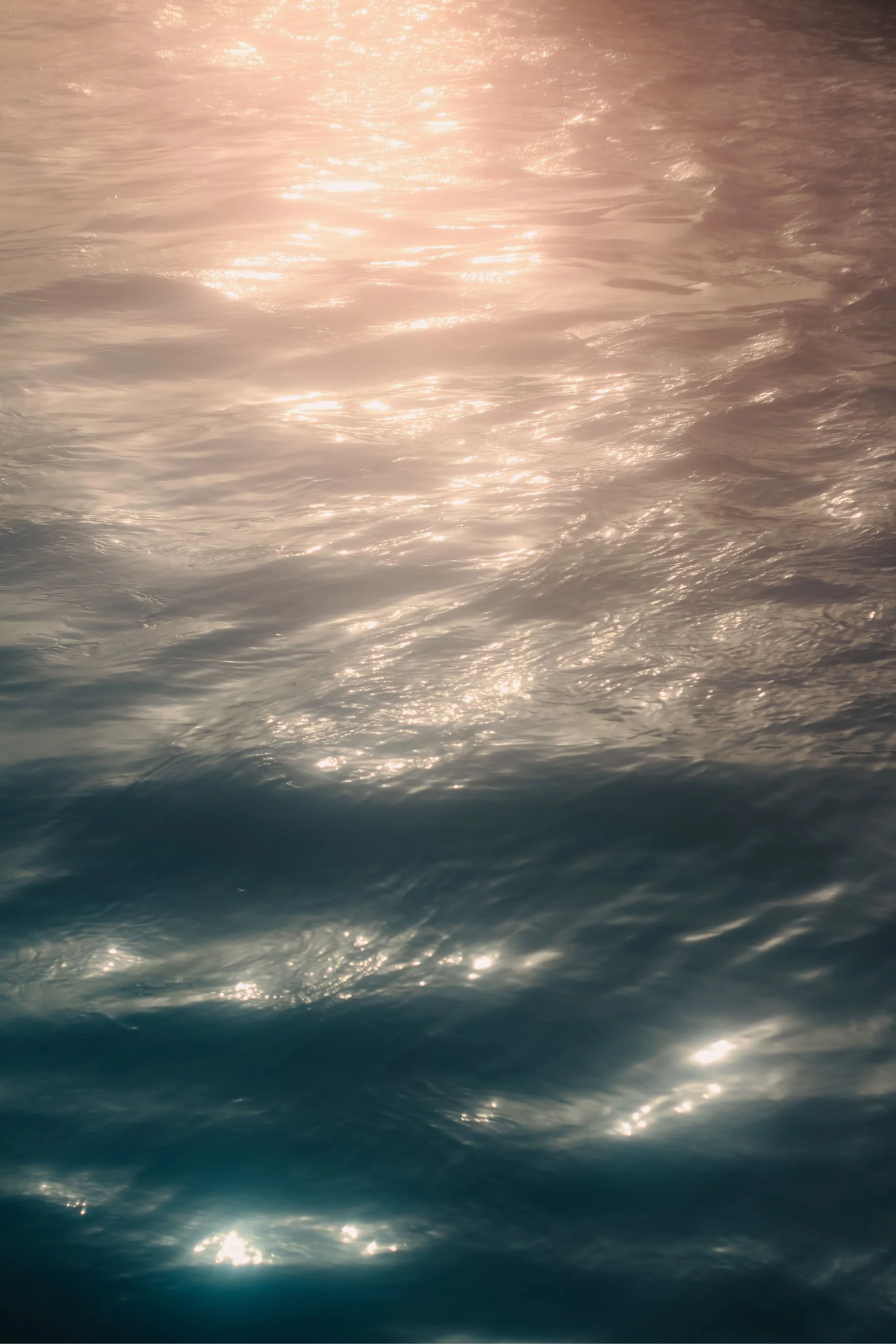 Sunlight reflecting on the surface of the ocean or sea, creating a shimmering effect with ripples and gentle waves.